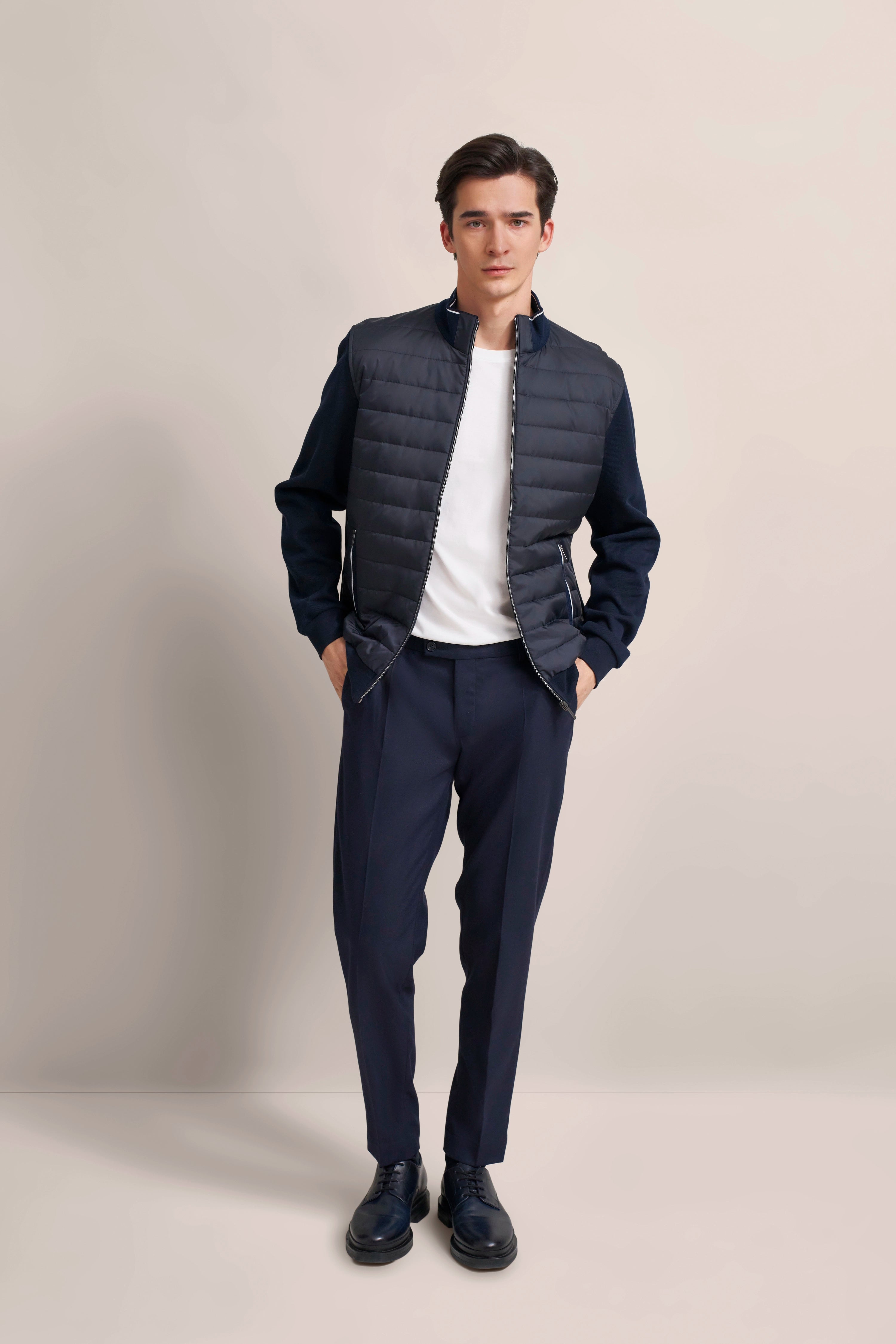 Model in navy Steppjacke und Hose, weißes Shirt, legeres Posing, bugatti Stil.
