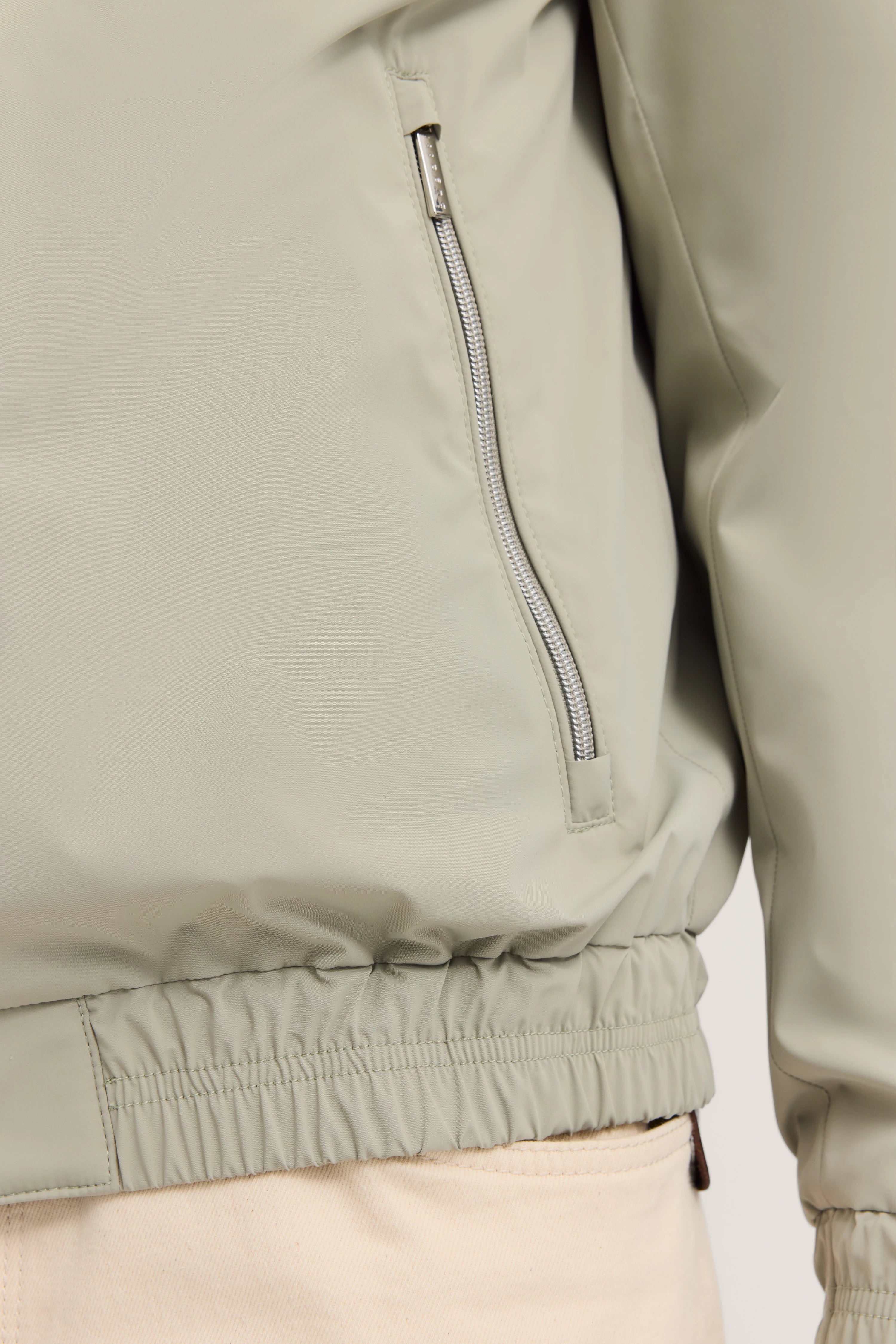 Beigefarbene bugatti Jacke mit elastischem Saum und Reißverschlusstasche, Büstenbild.