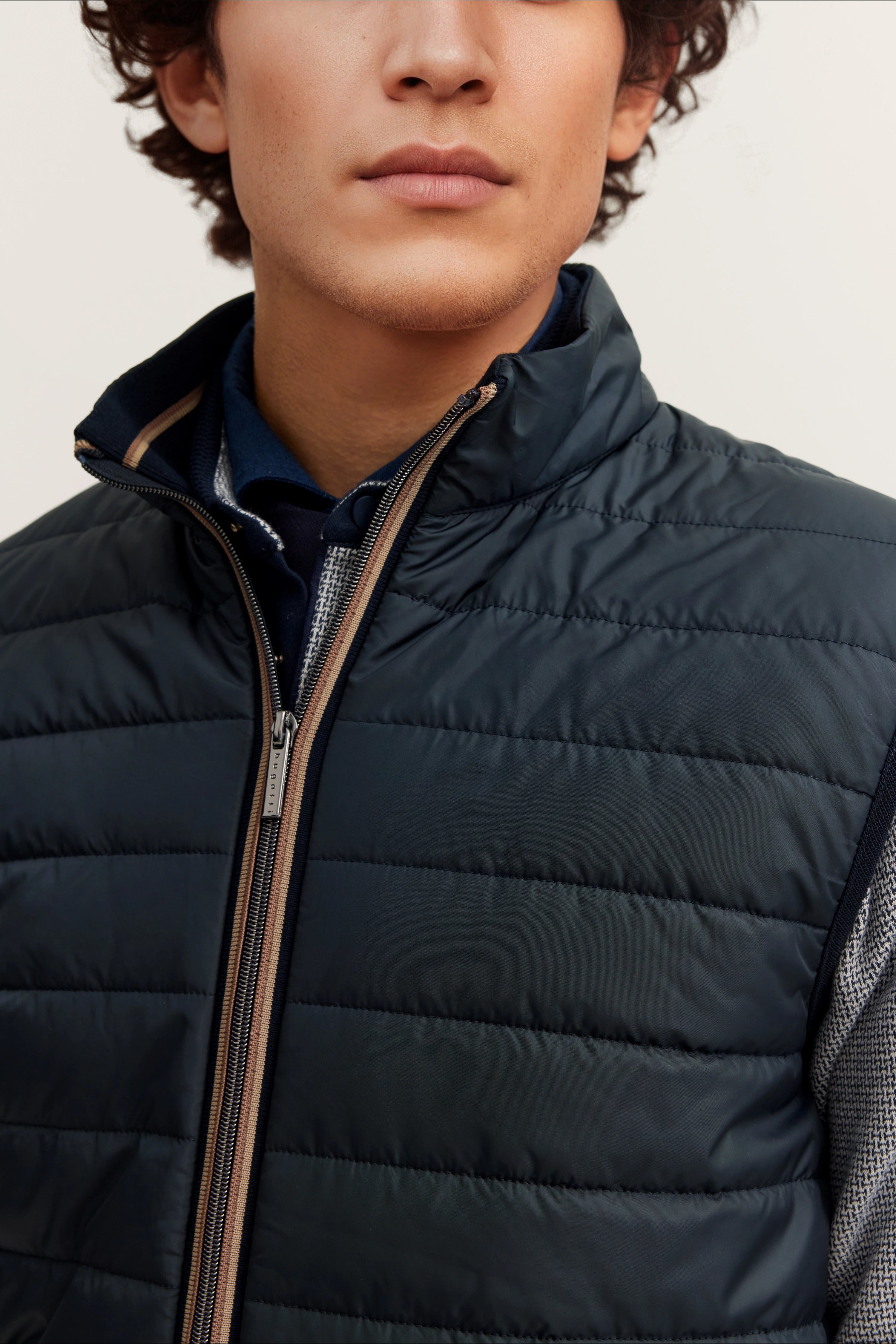 Navy Steppweste von bugatti, Detailaufnahme, über blauem Hemd mit gemustertem Kragen.