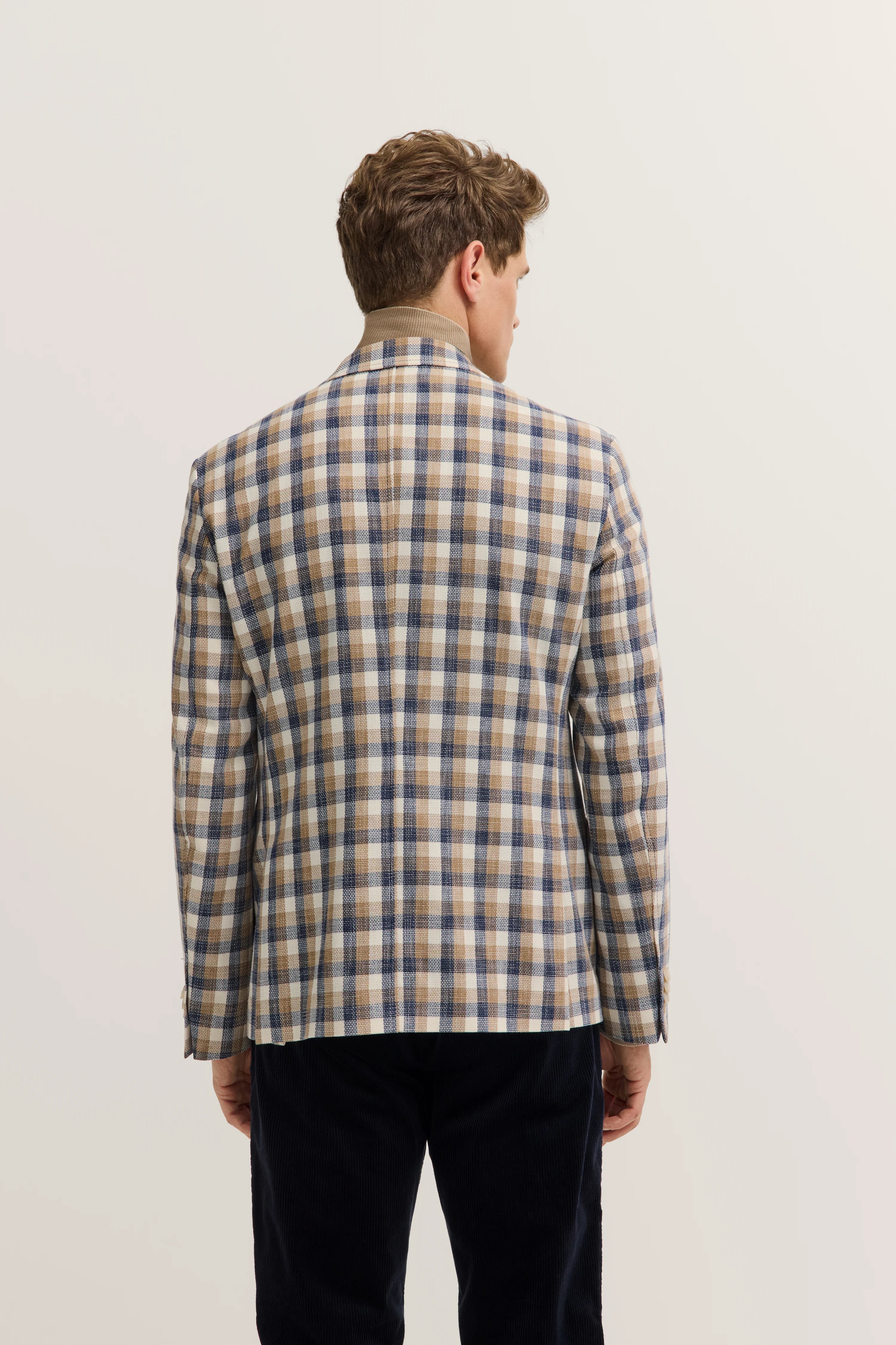 Büstenbild eines Mannes in bugatti kariertem Sakko in Beige und Blau.