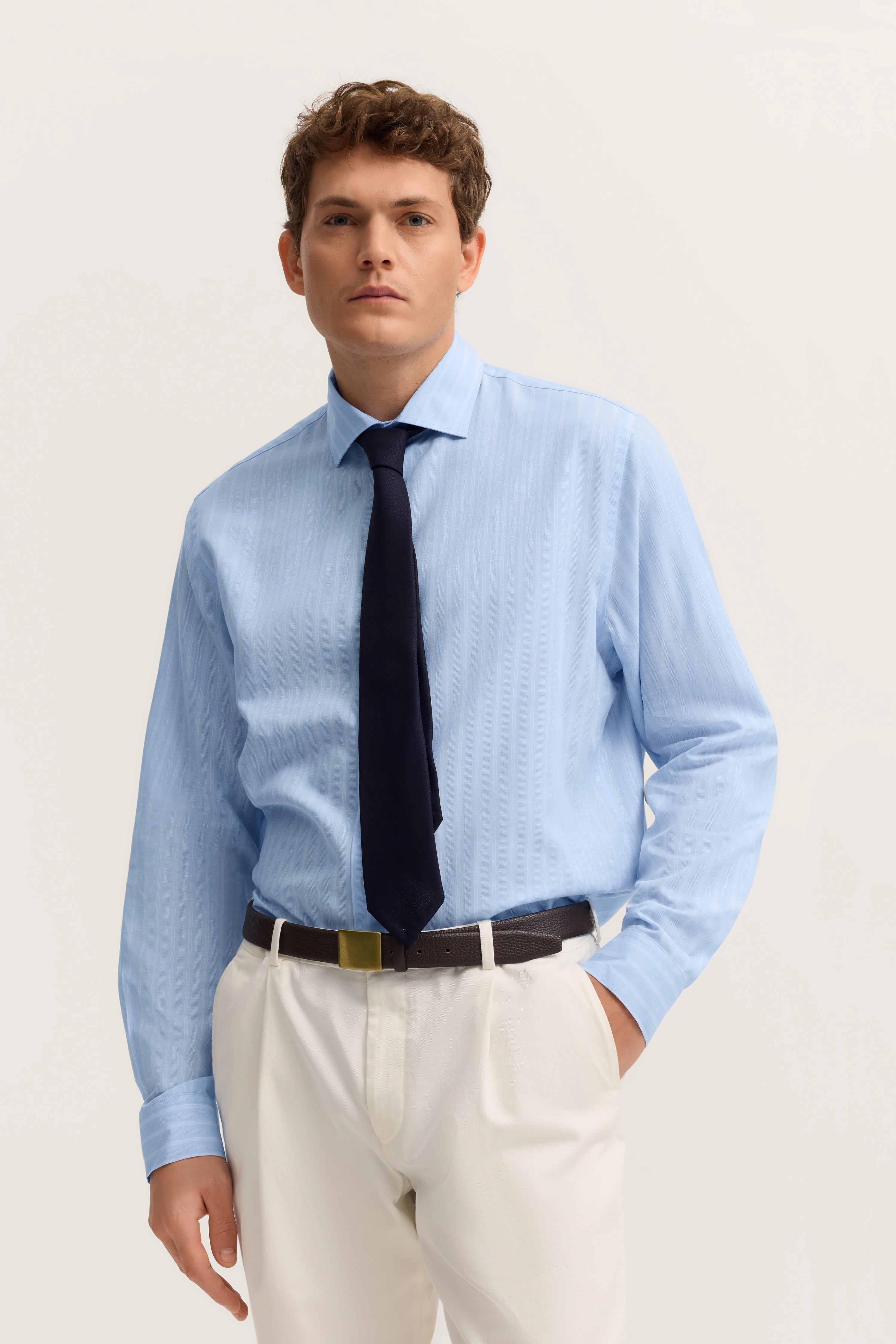 Hellblaues Hemd, schwarze Krawatte, weiße Hose