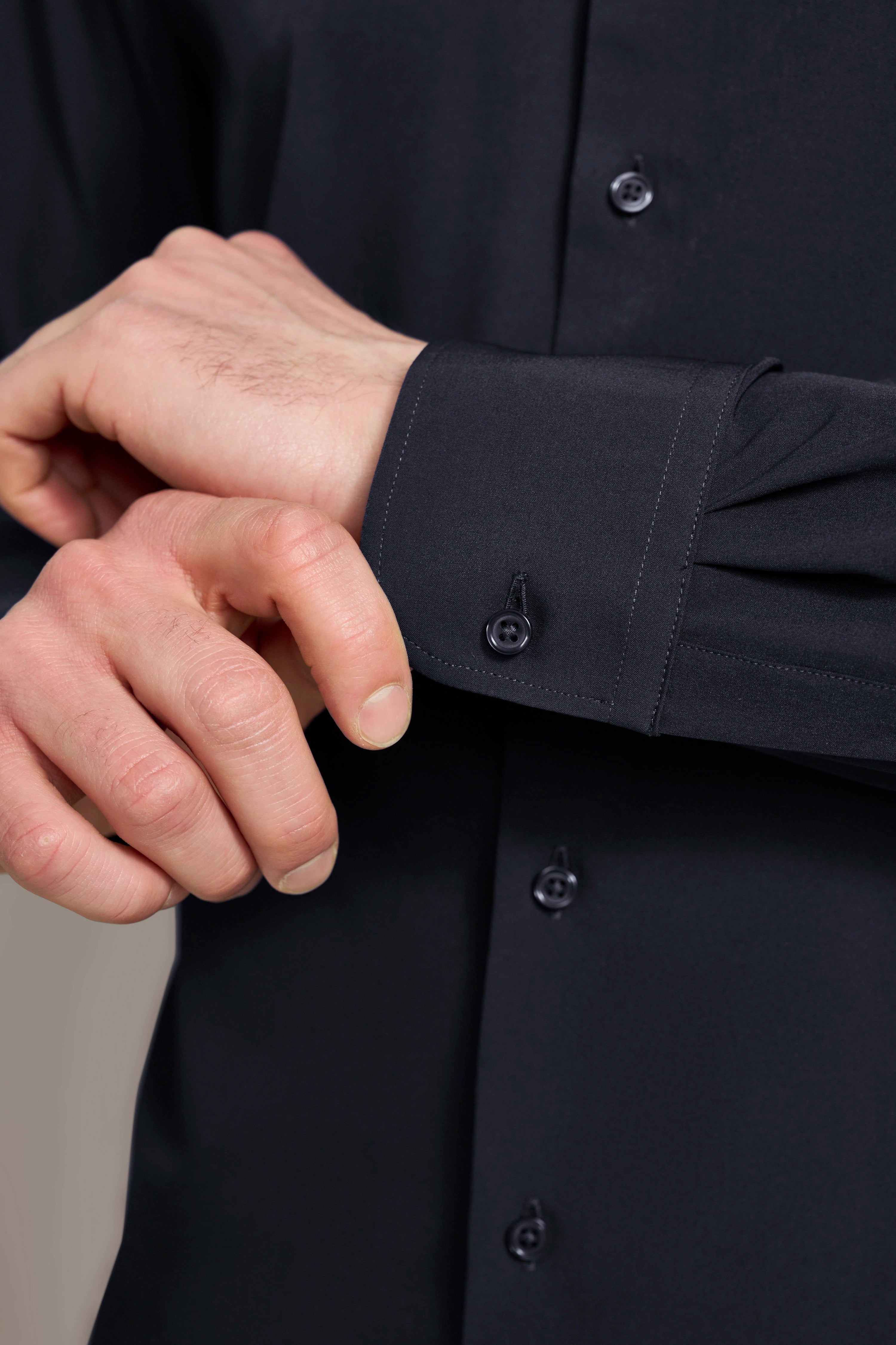 Hemd in Dunkelblau, Nahaufnahme der Manschette, detailreiche Knöpfe, legeres Bild, bugatti Stil.