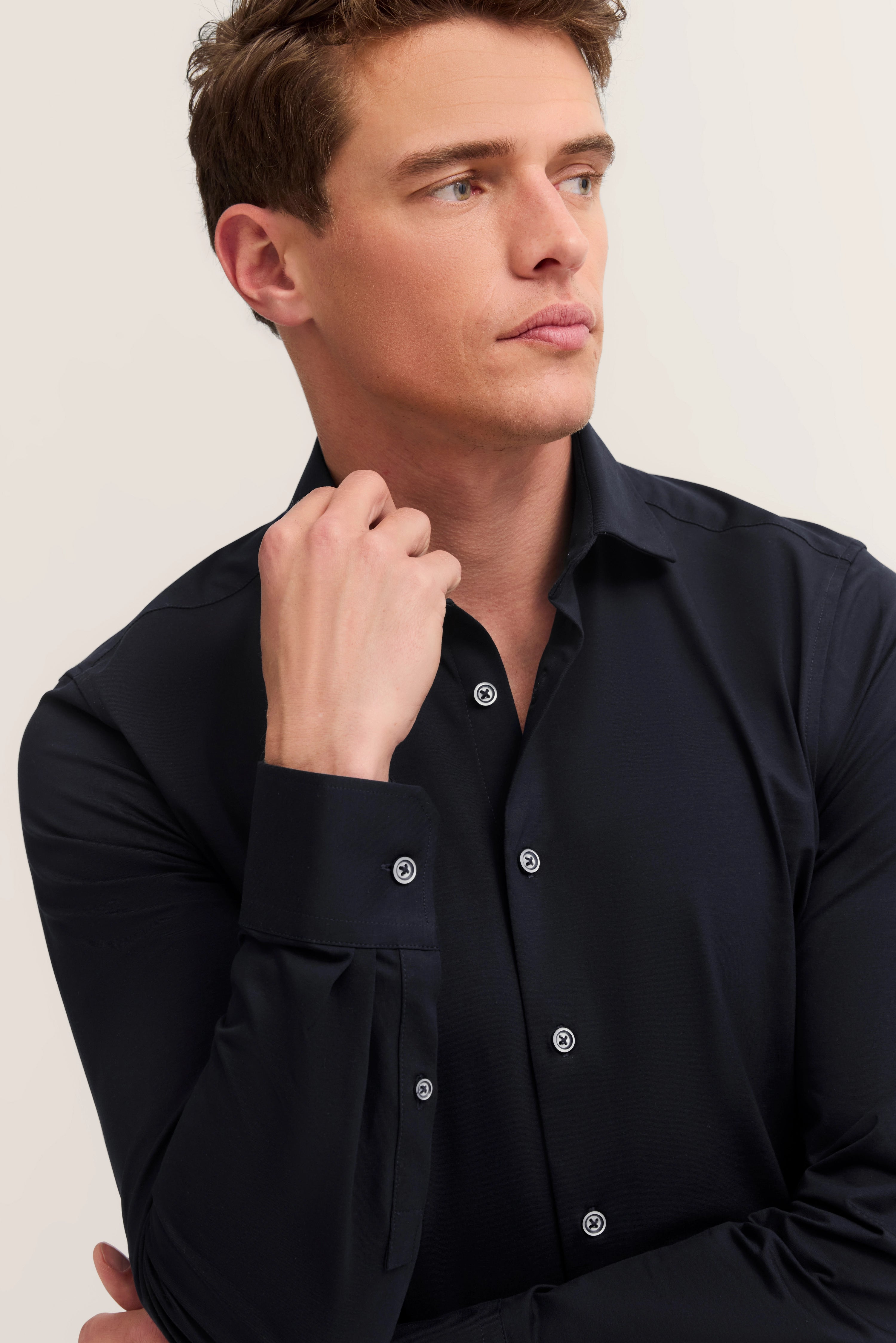Elegantes Modelbild: Dunkles bugatti-Hemd mit klassischen Knöpfen, lässige Pose, stilvoll und zeitlos.
