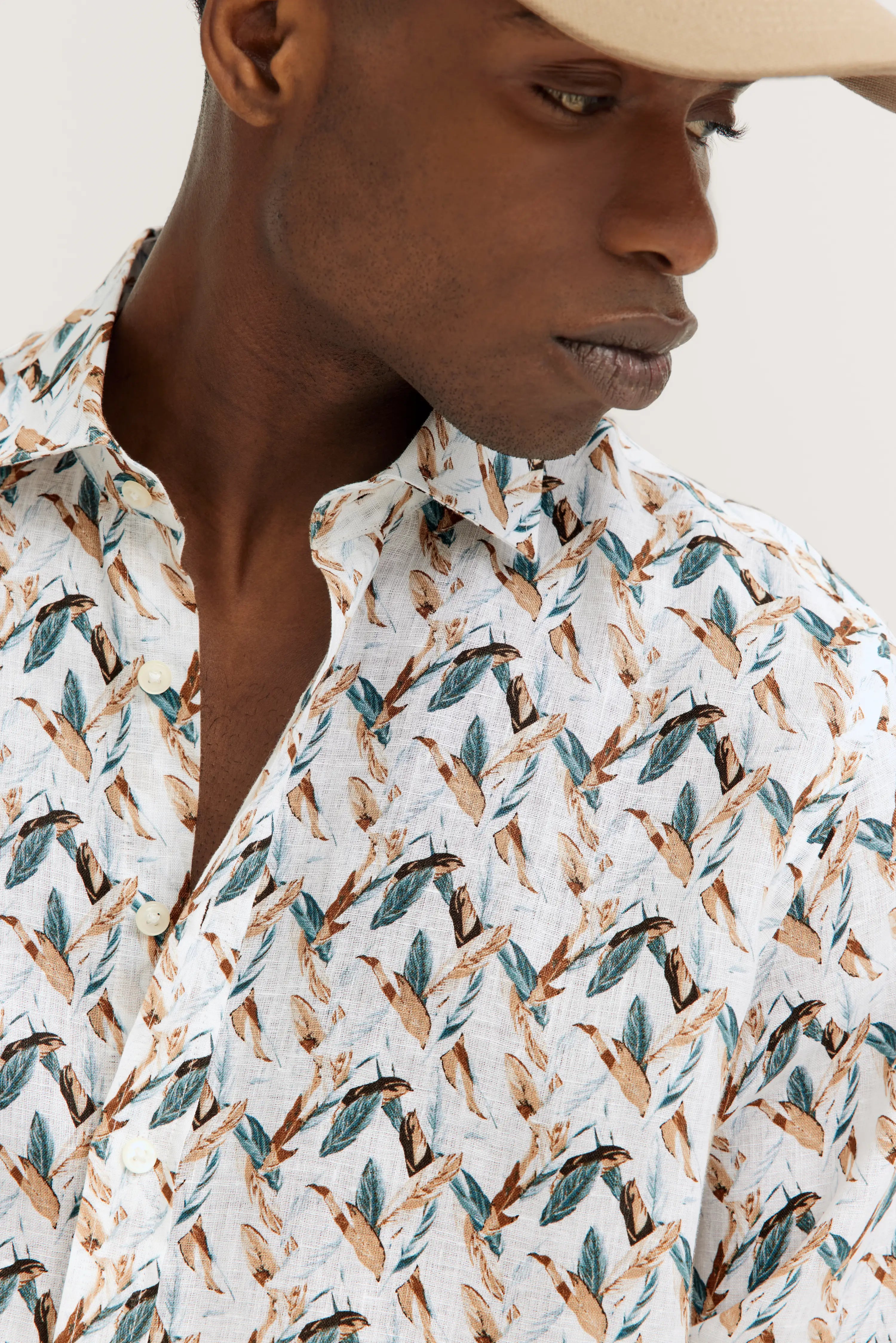 Hemd mit Blattmuster in Braun und Grün auf weißem Hintergrund, Model von der Seite, bugatti Stil.