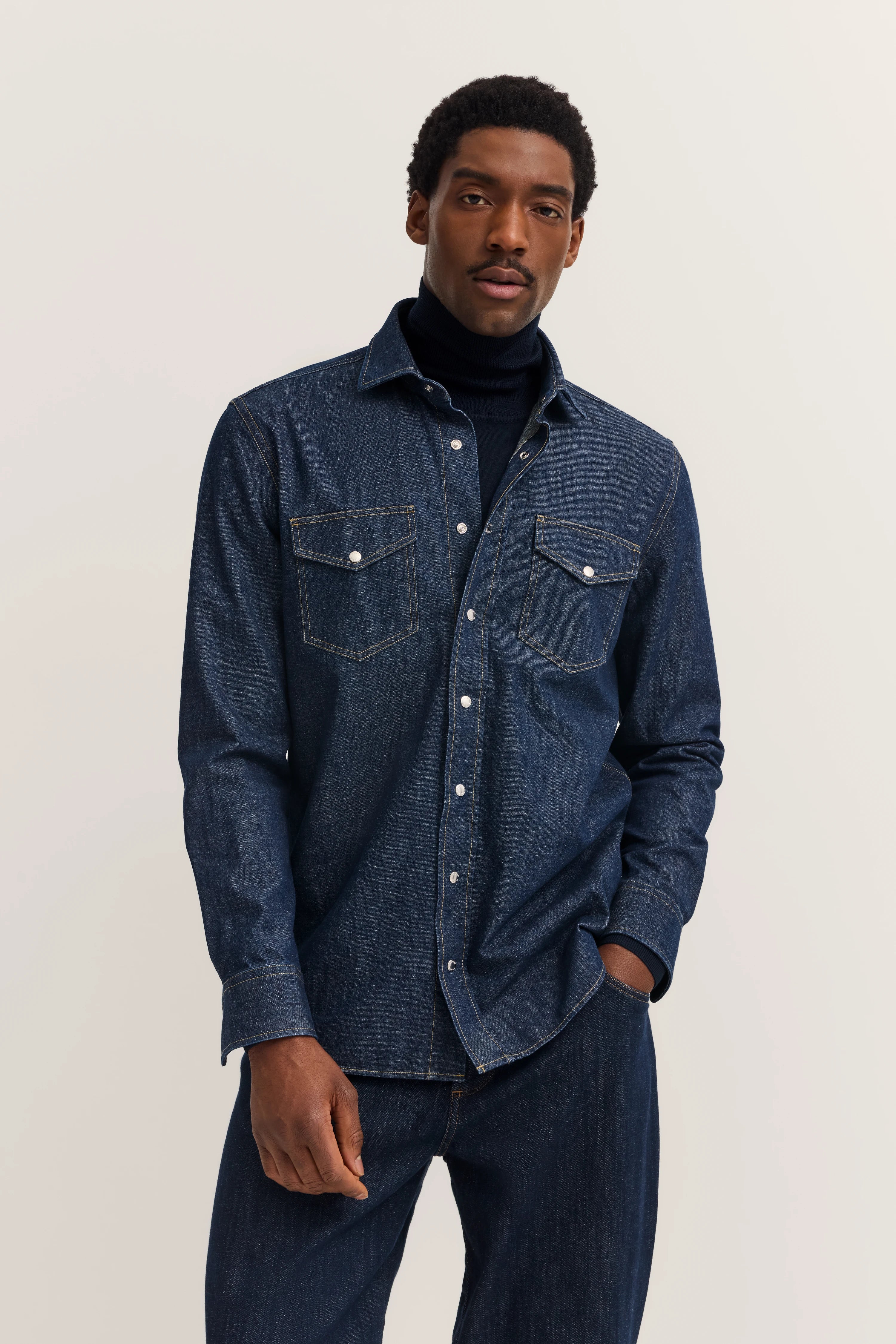 Dark blue denim shirt and jeans, model in casual pose.