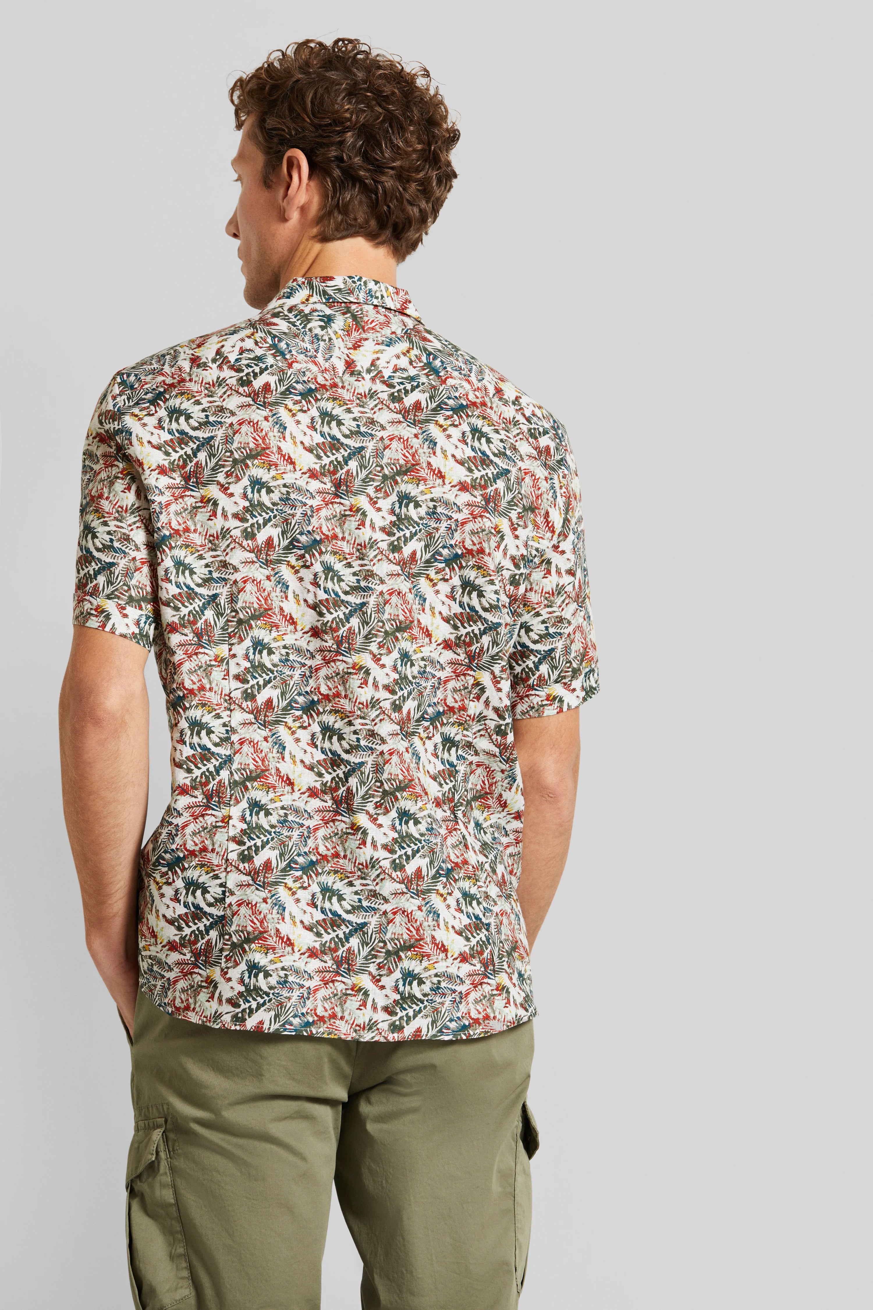 bugatti shirt with floral pattern in beige, red, and green, paired with olive green pants. Model shown from back.