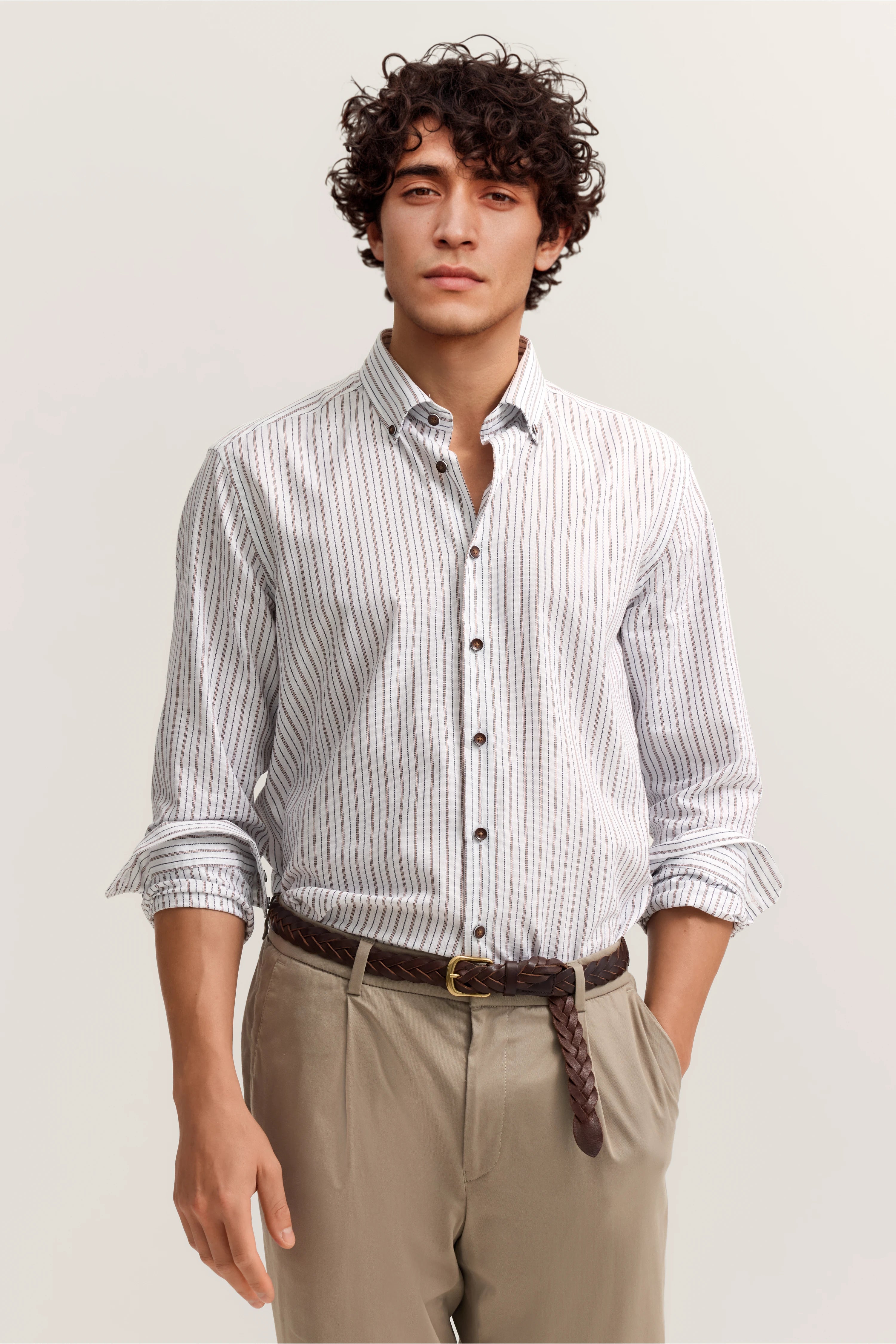 Modelbild, weiß-blau gestreiftes Hemd, beige Hose, lässige Pose, bugatti Stil.