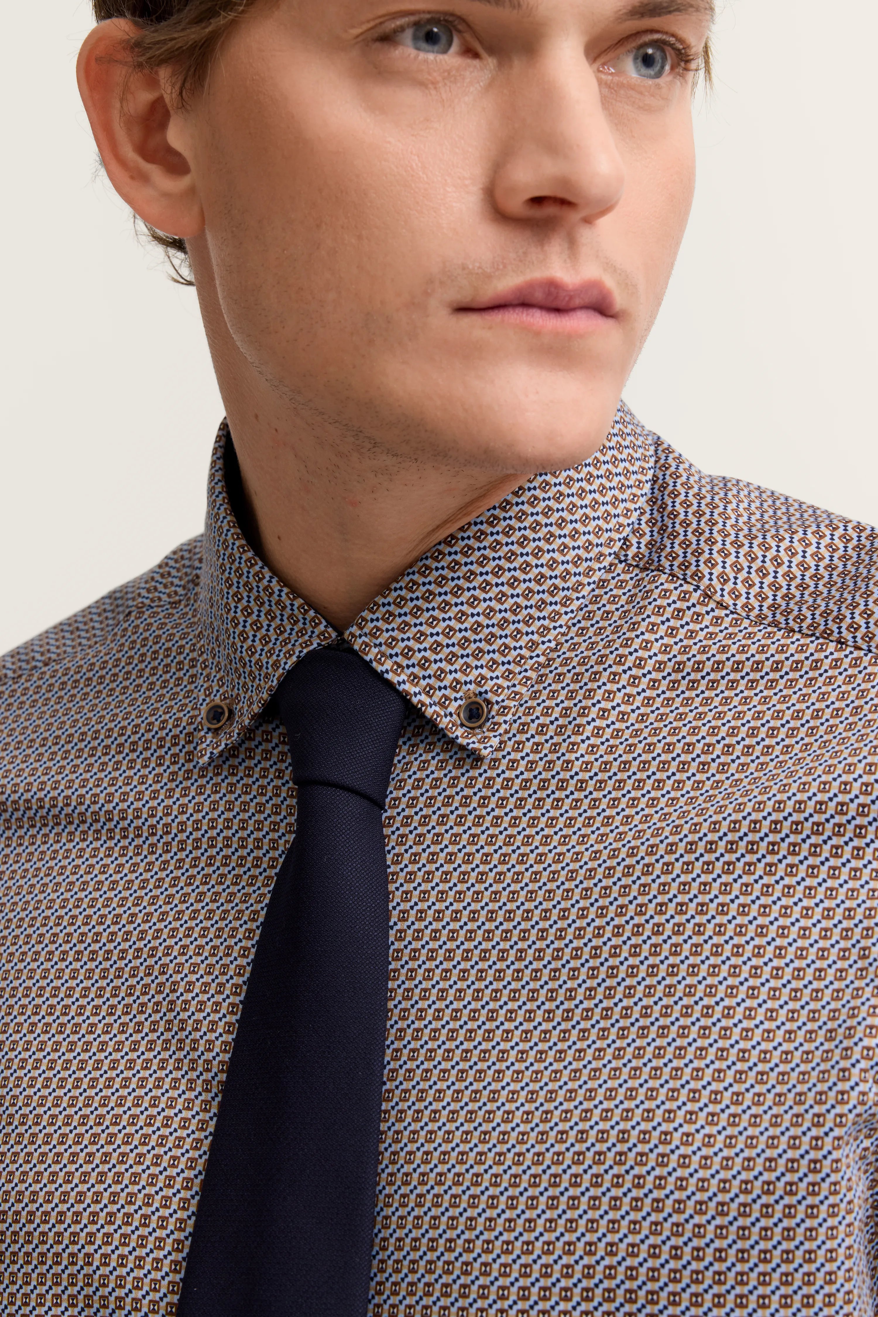 Büstenbild mit gemustertem Hemd in Blau-Braun, dunkelblaue Krawatte, stilvoll für bugatti.