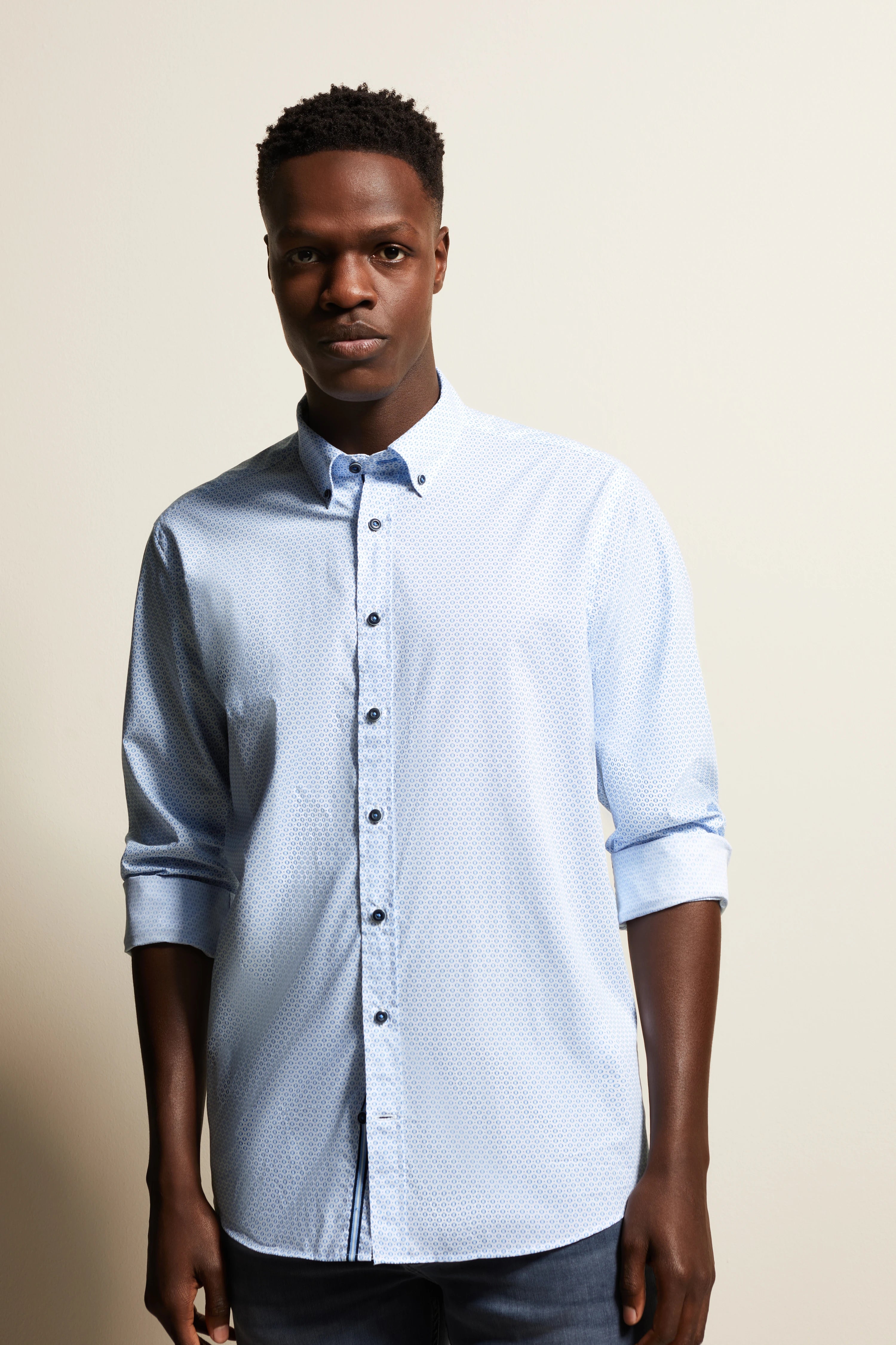 bugatti model image: Light blue shirt with fine pattern, casually rolled-up sleeves, confident pose.
