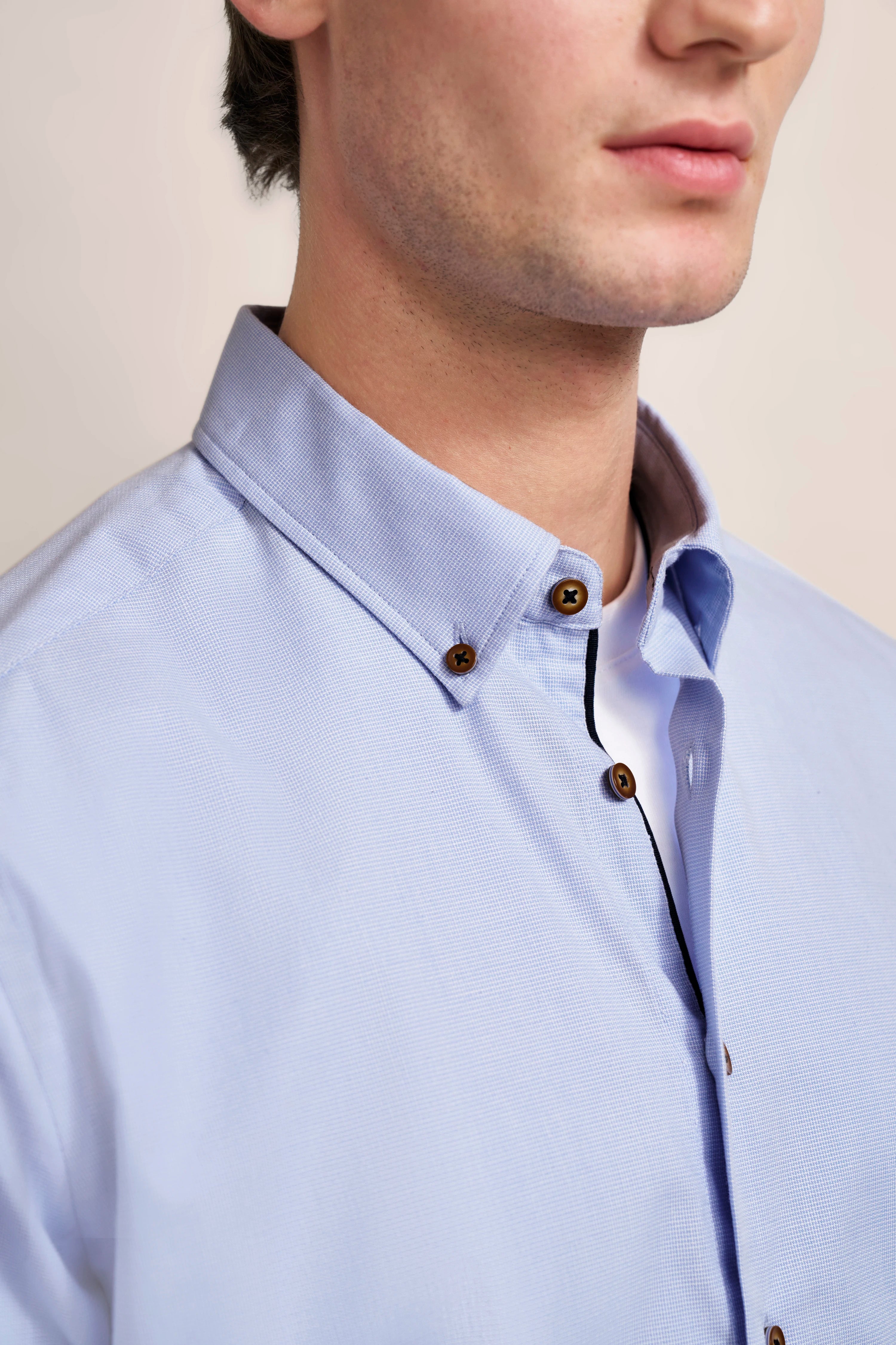 Light blue shirt with button placket, detailed view, casual bust shot.