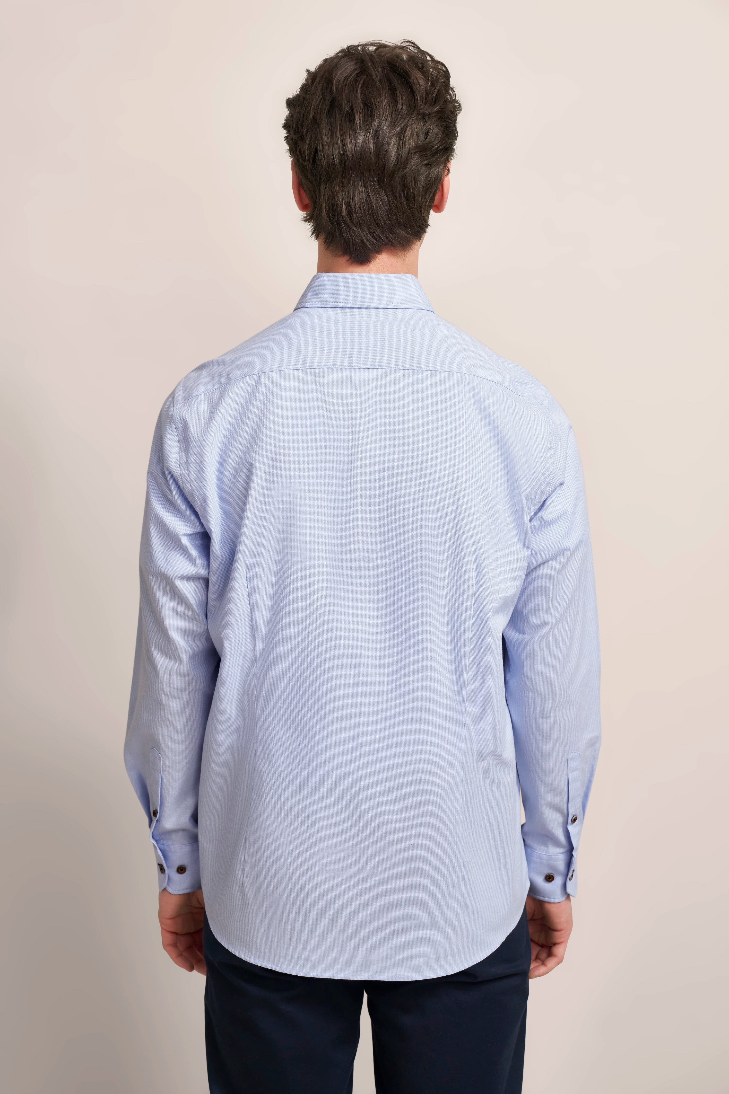 Blue bugatti shirt with subtle pattern, model from behind, relaxed pose.