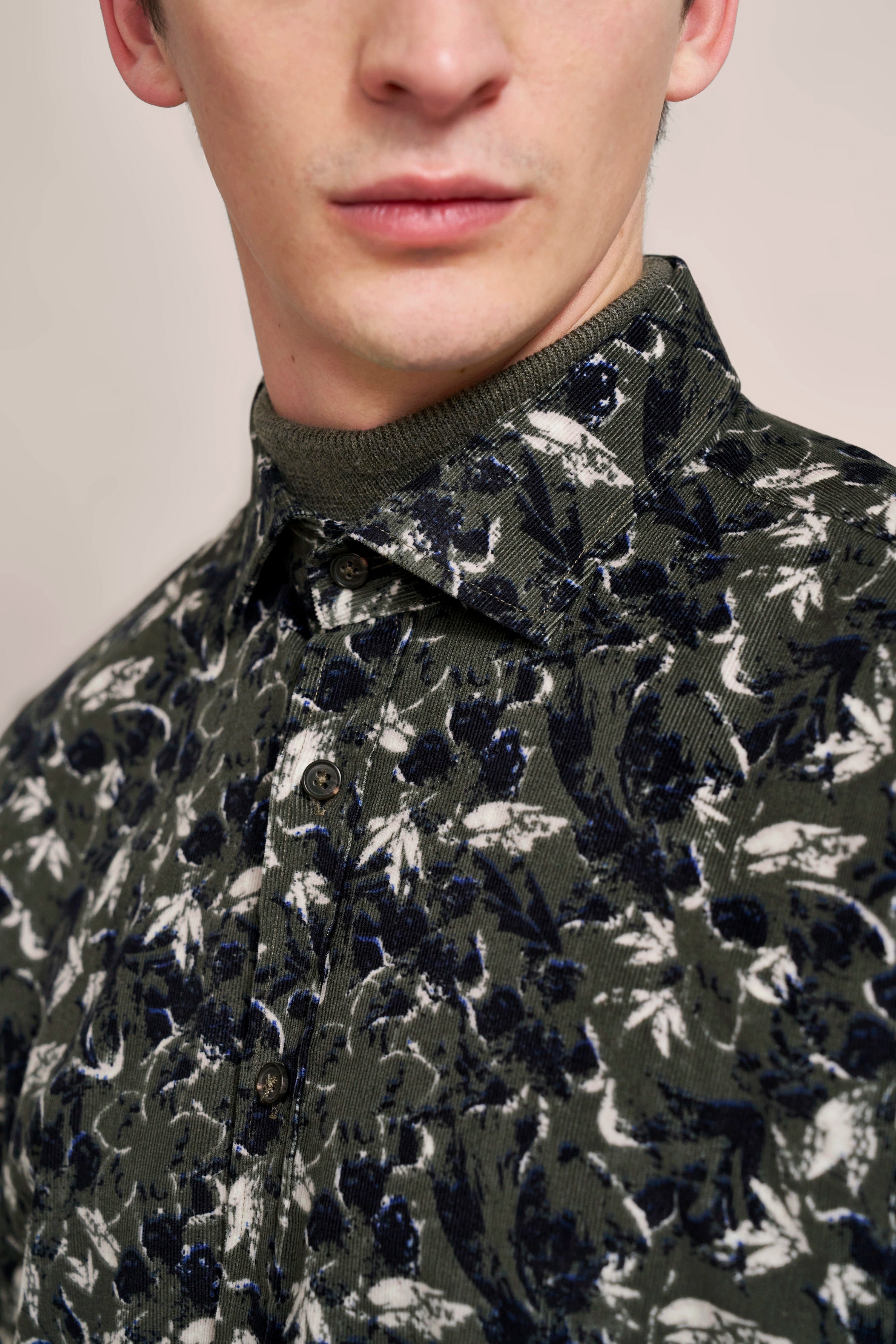 Green patterned bugatti top with floral design on bust image.