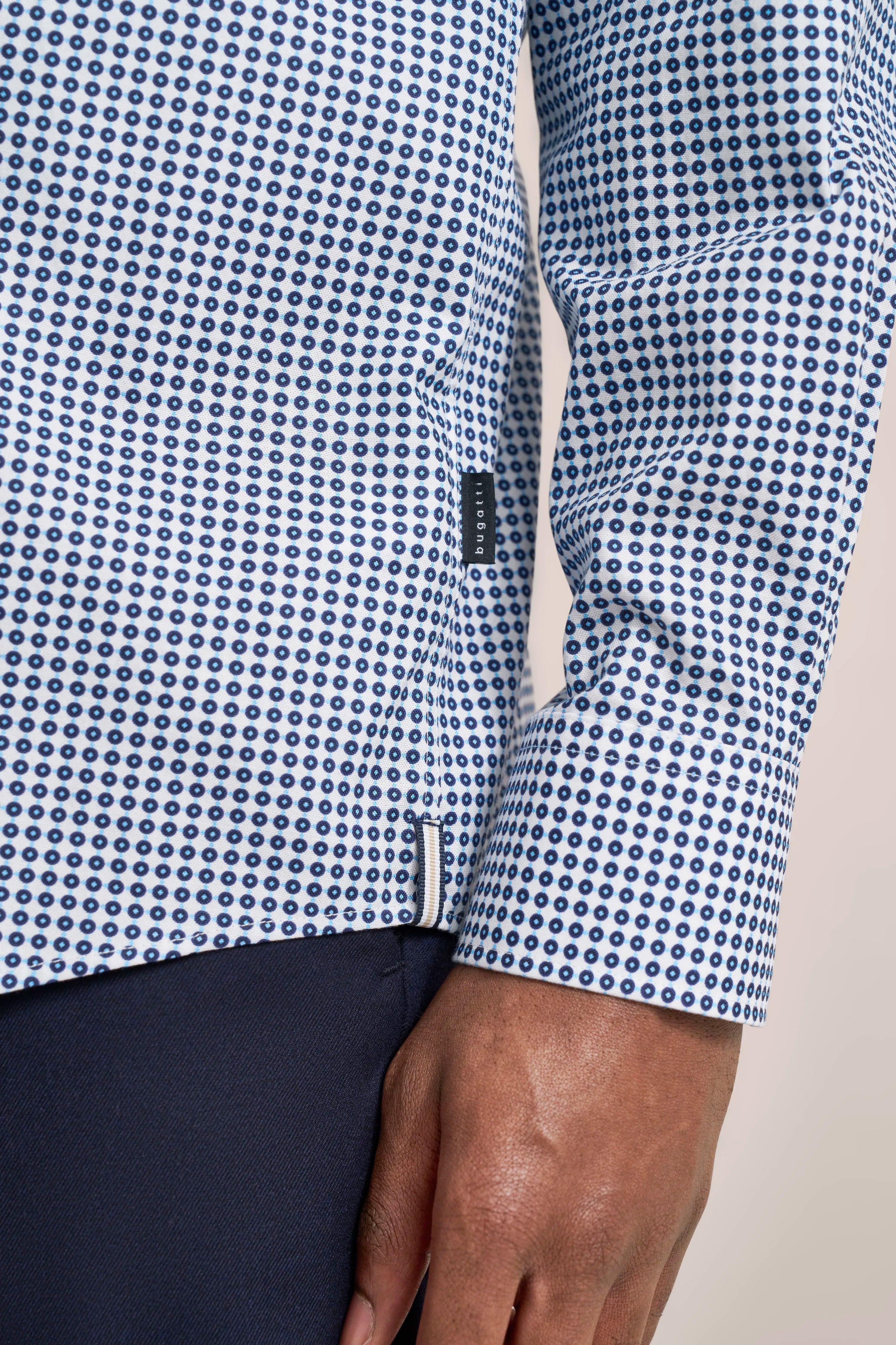 Blue-white patterned bugatti shirt, close-up, casual, paired with dark trousers.