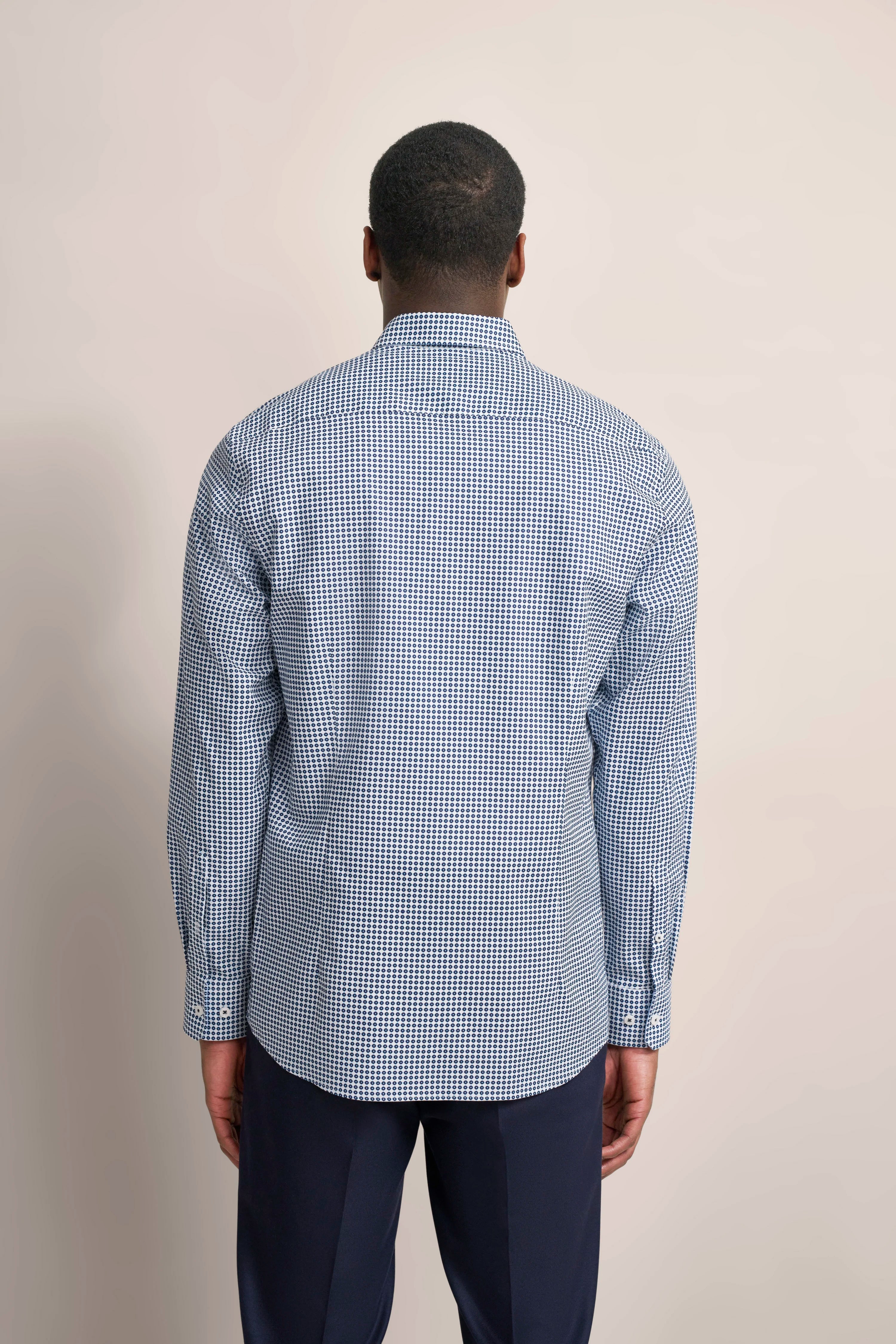 Back view of model in blue-white checked bugatti shirt, dark blue pants.