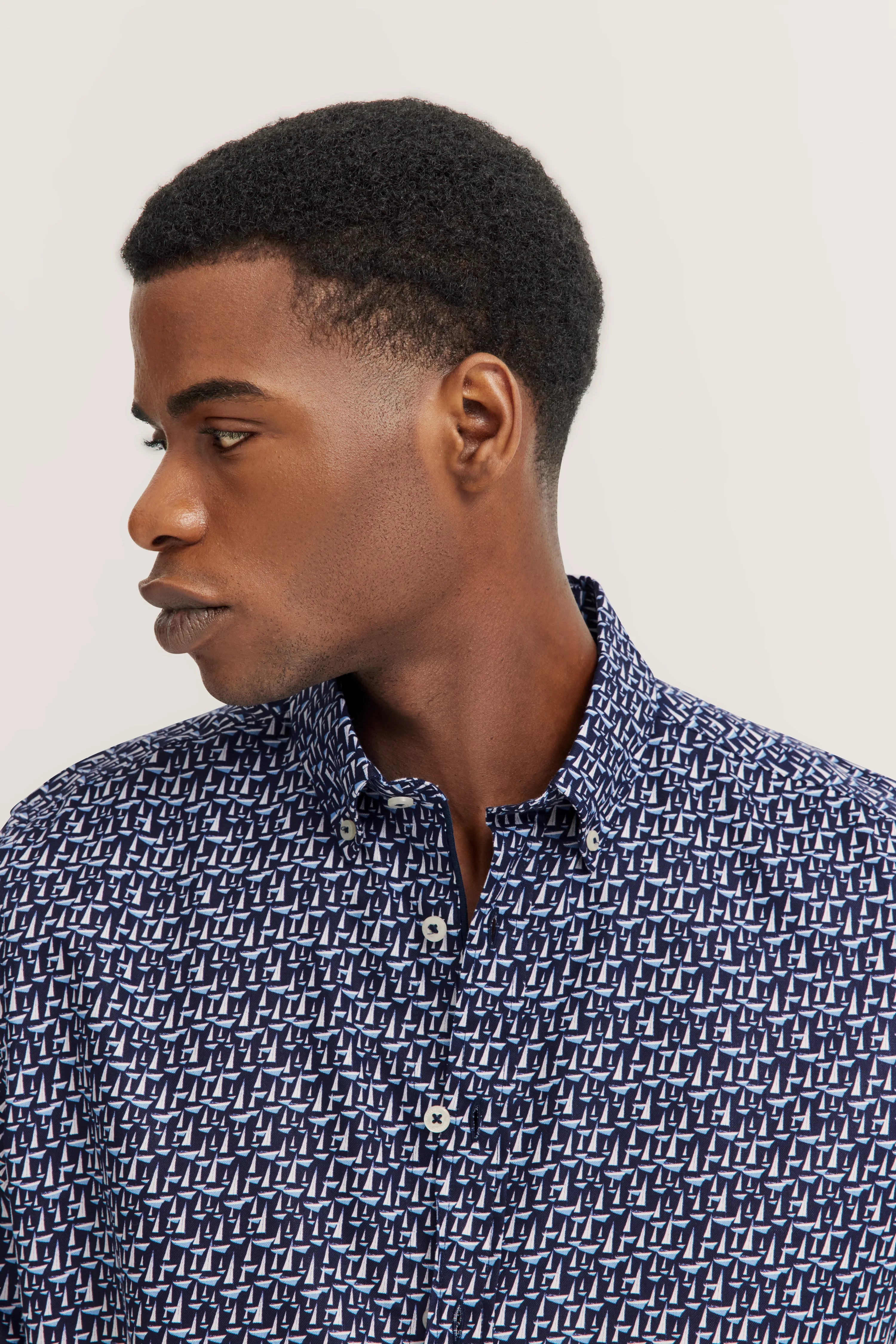 Bugatti Hemd mit blauem Segelbootmuster, Model von der Seite, eleganter Look.