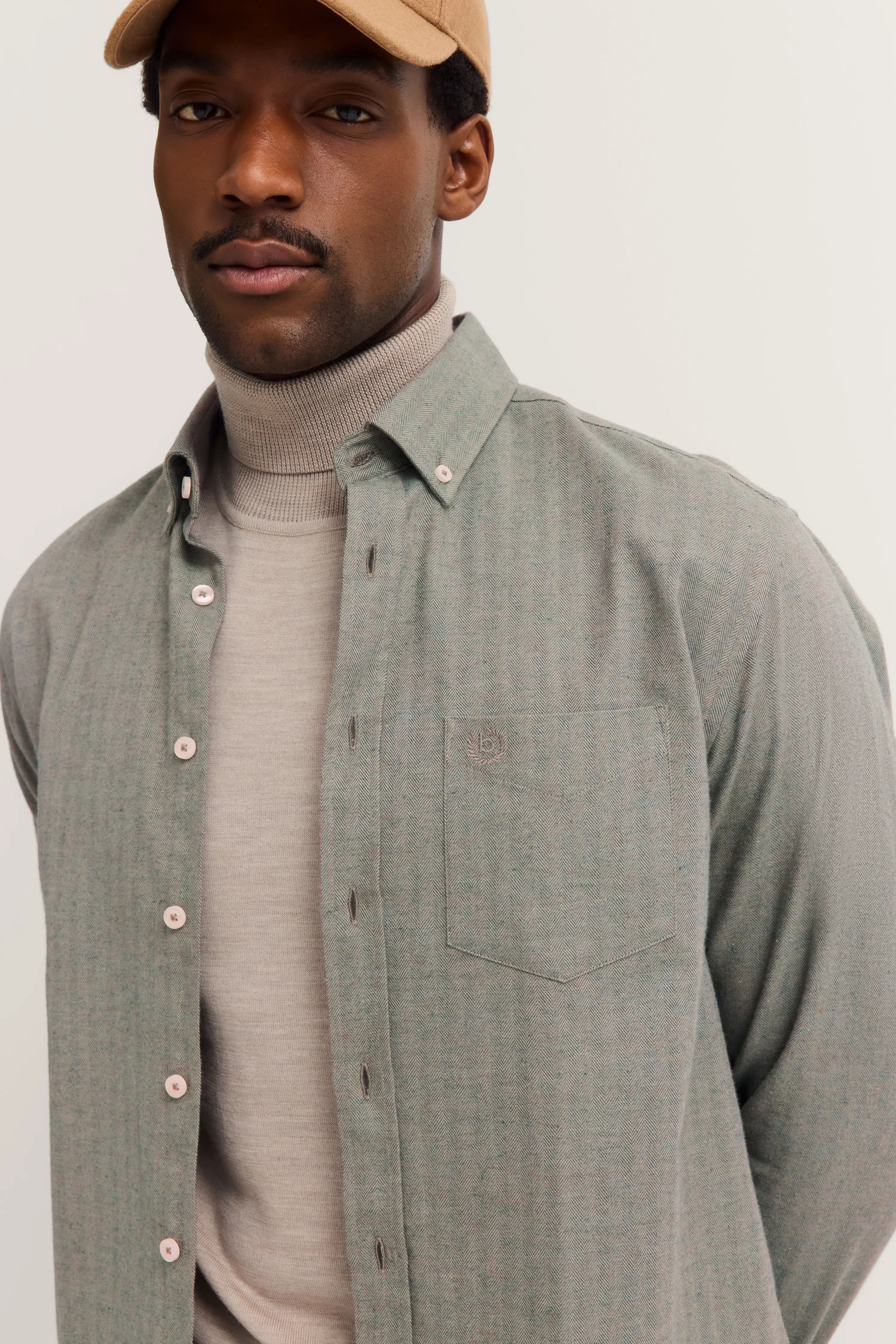 bugatti model: Beige turtleneck sweater and gray shirt, casual pose, elegant look.