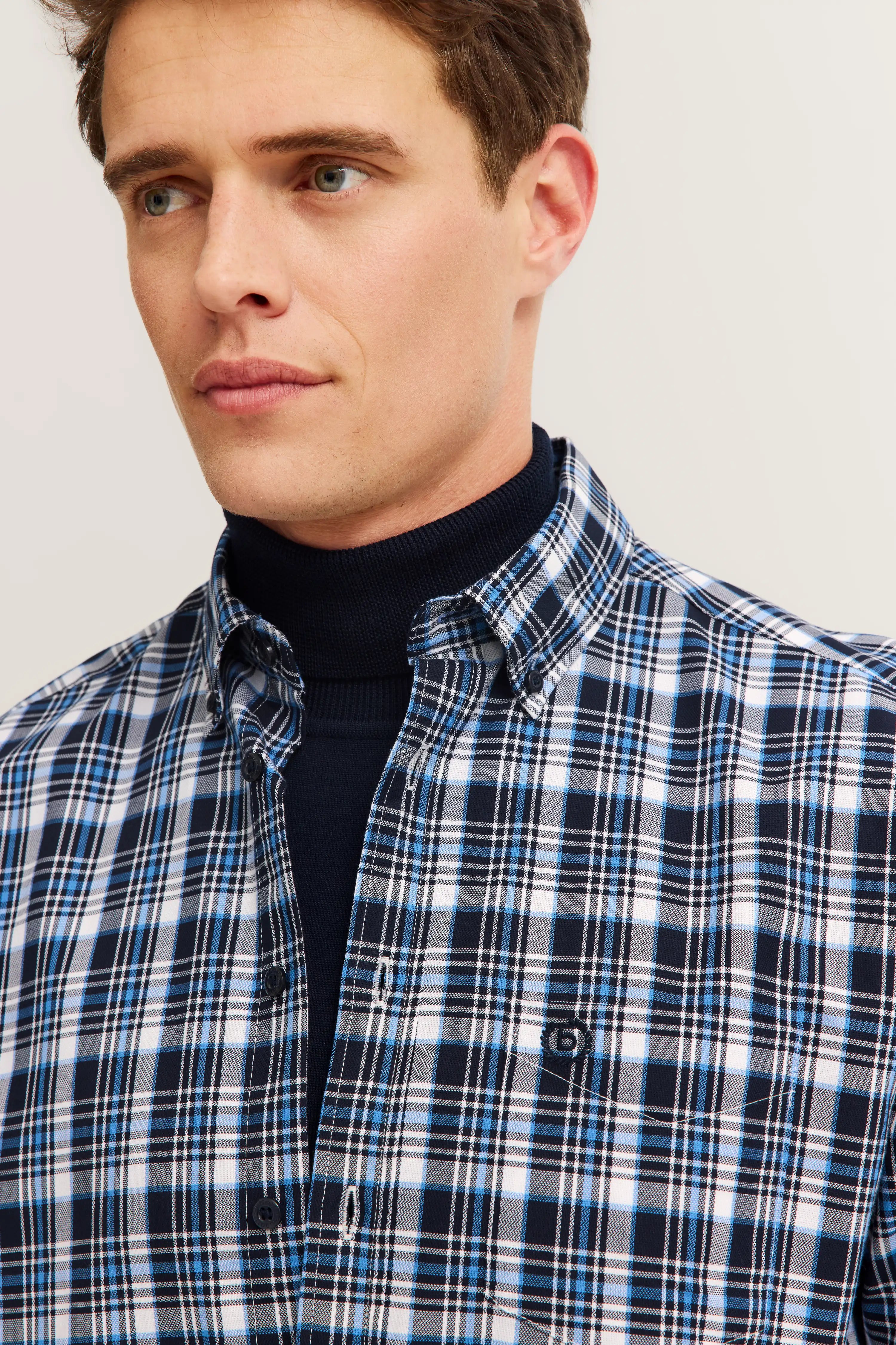 Herrenmodel in blau-weiß kariertem bugatti Hemd, Büstenbild, stilvoll und klassisch.