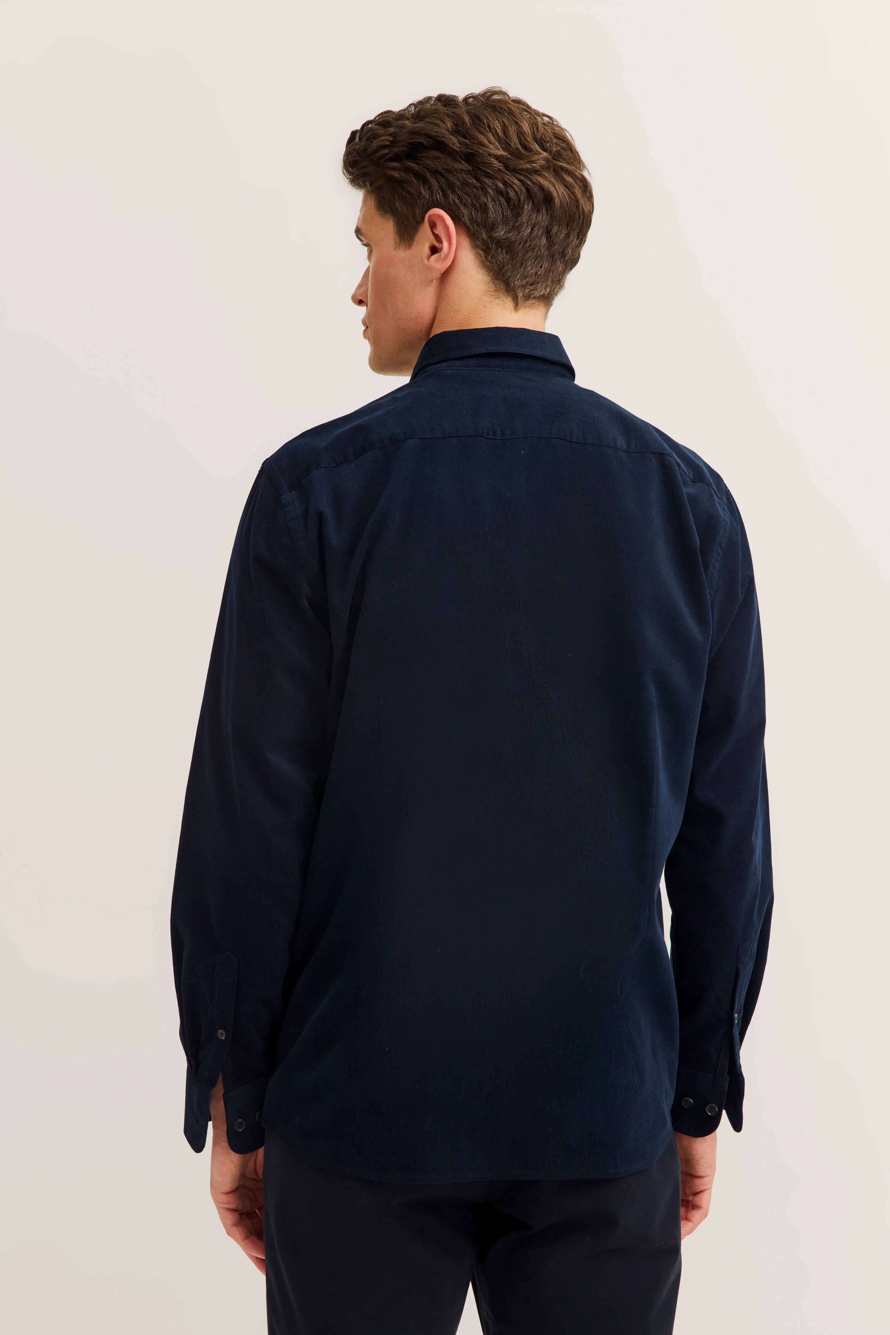 Blue bugatti shirt, back view, worn by model, casual pose, highlighting premium materials.