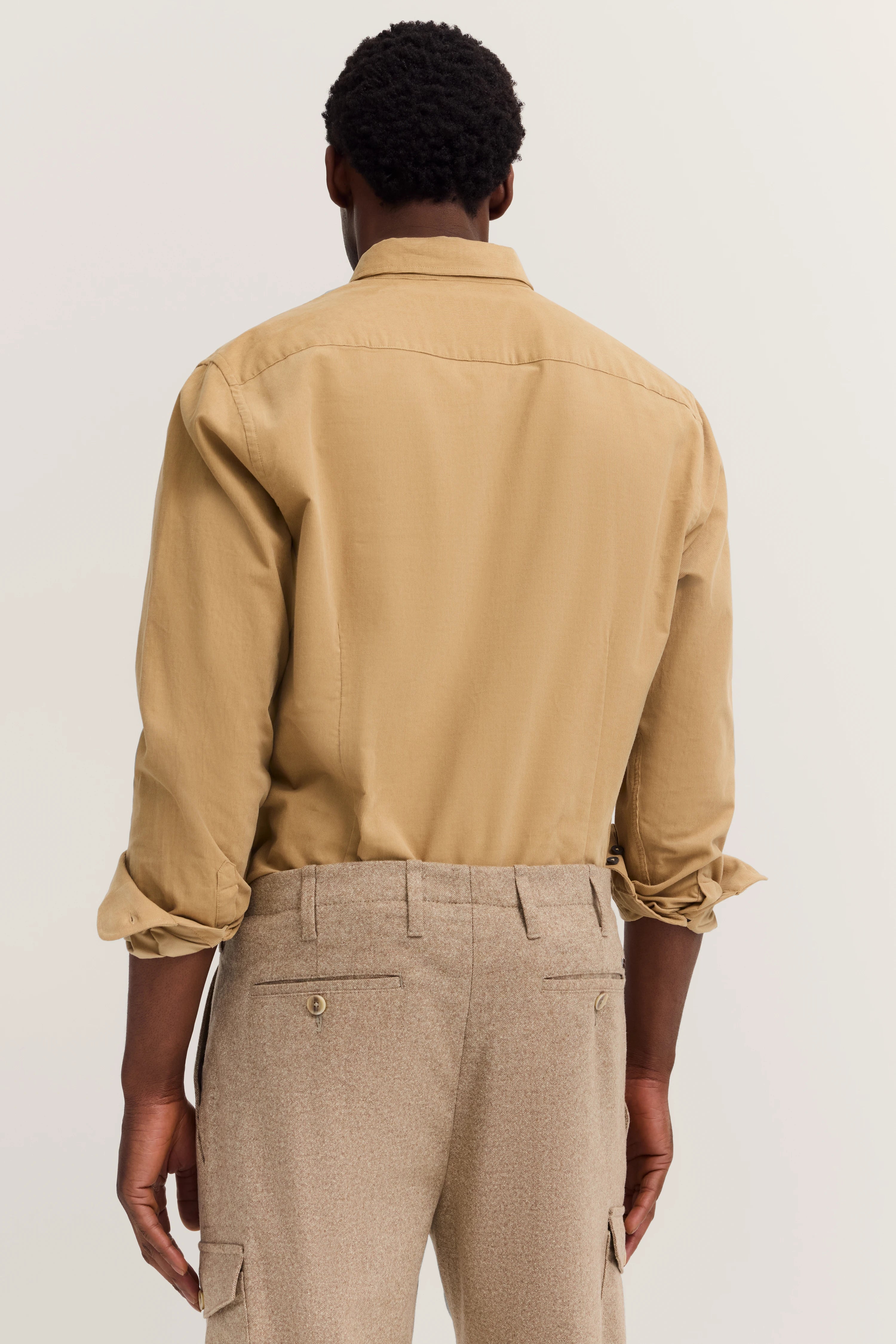 Rear view: Beige bugatti shirt and light brown trousers, casual outfit.