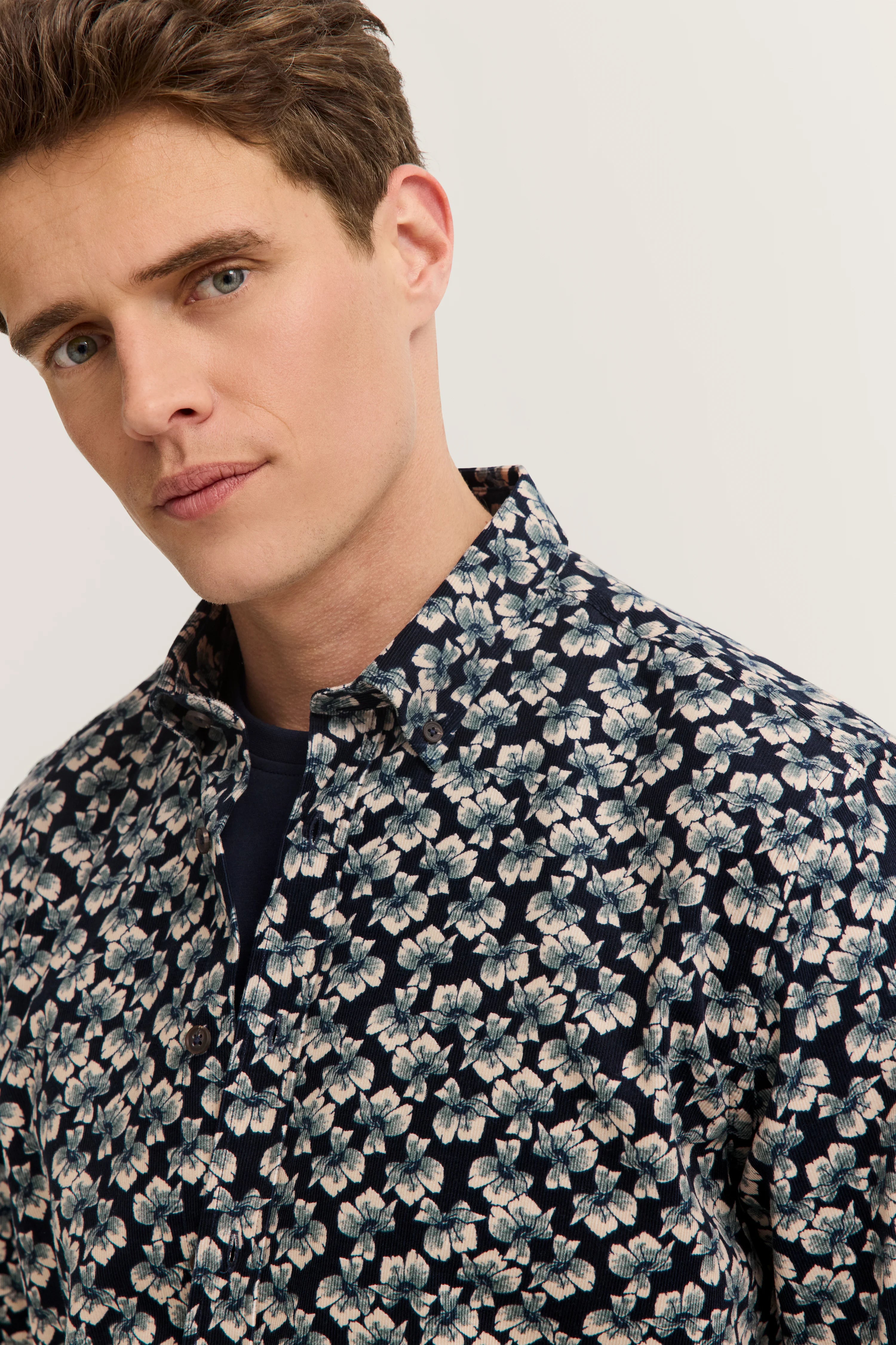 Blue floral bugatti shirt, model smiling softly, relaxed vibe.