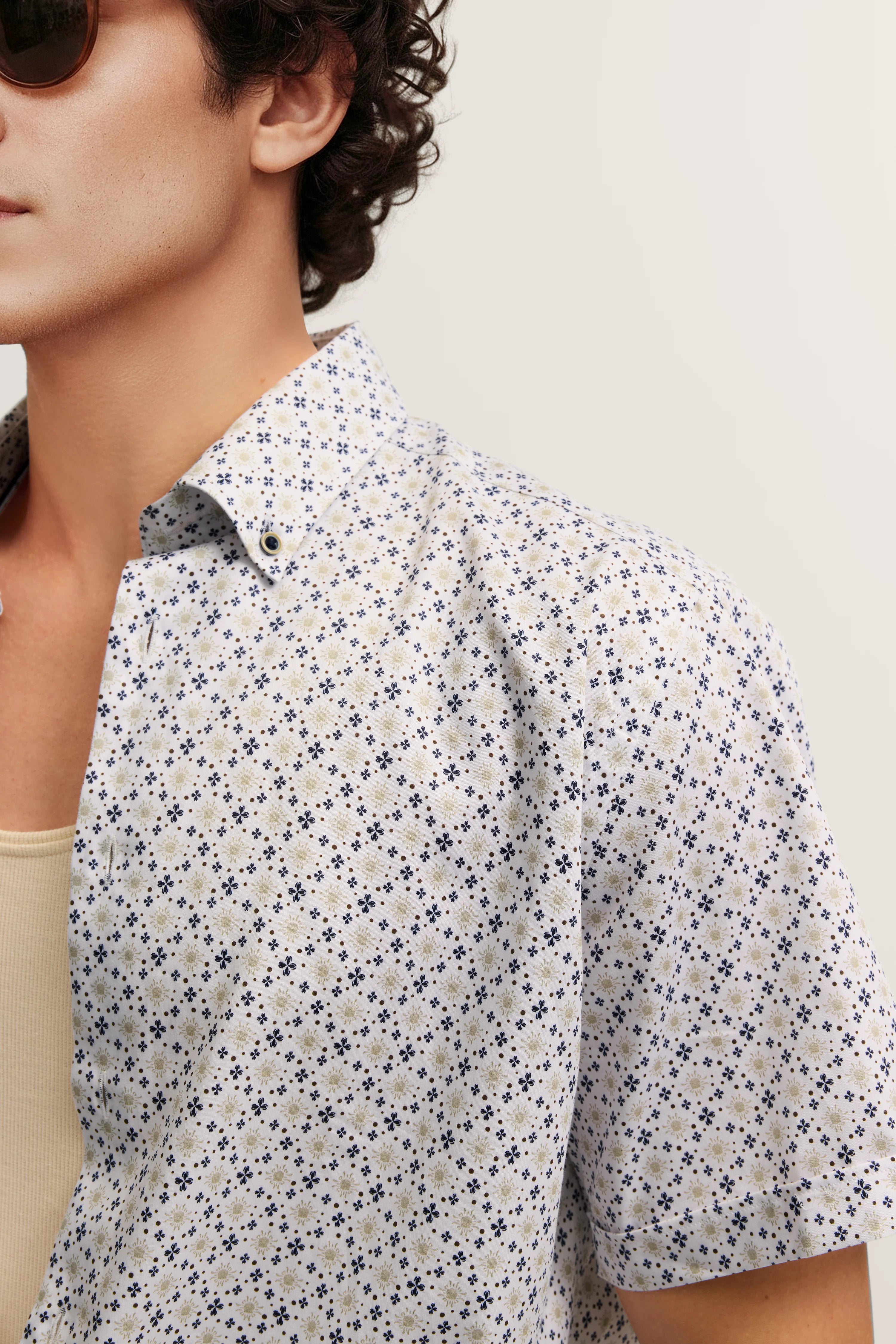 Hemd mit floralem Muster in Blau und Beige, Modelbild, entspanntes Posing, sommerlicher Look.