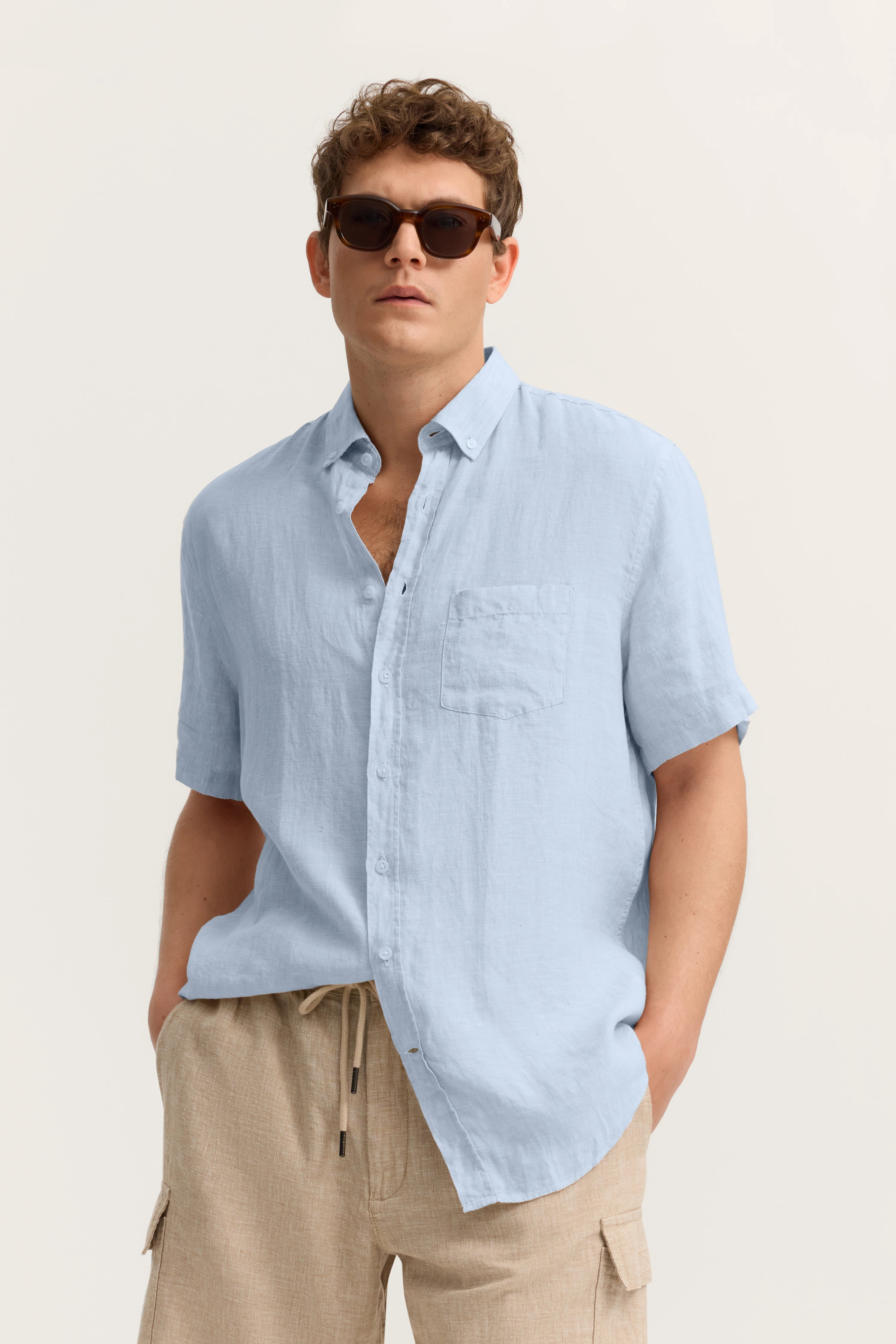 Leichtes, blaues Leinenhemd und beige Shorts