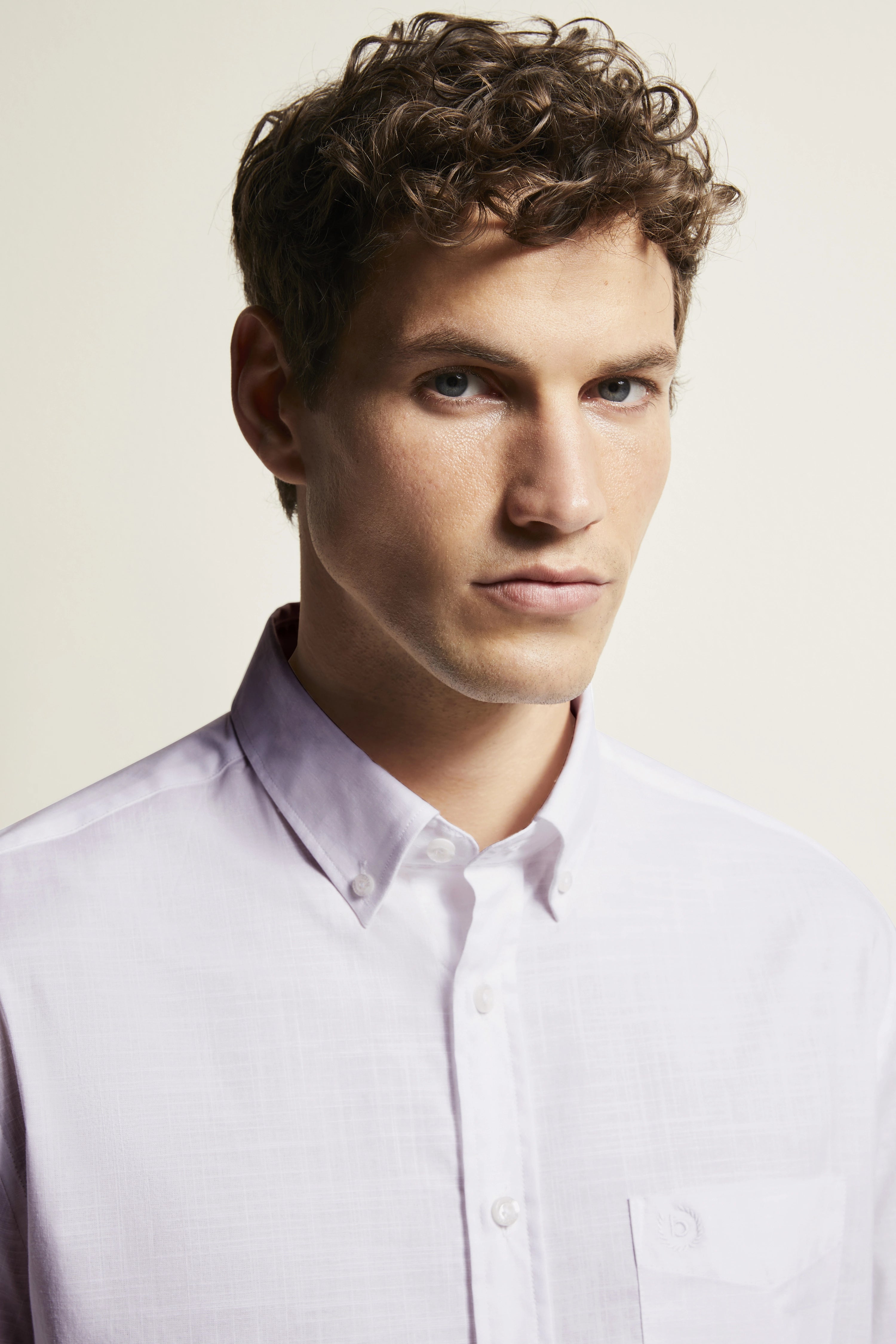 Bust of model in white bugatti shirt with button-down collar, simple design.