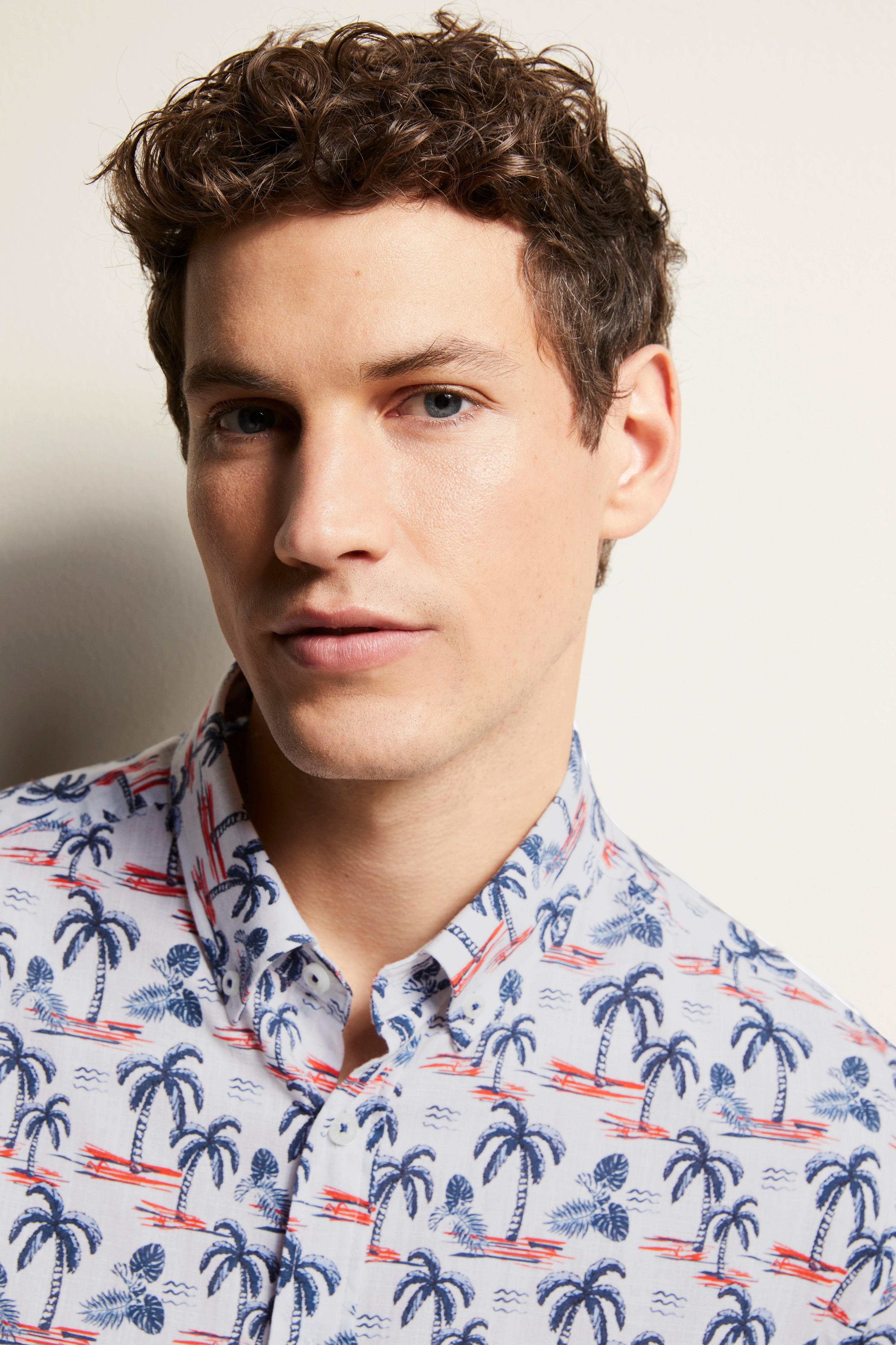 bugatti Hemd mit Palmenprint in Blau und Rot auf Weiß, legeres Büstenbild, sommerlicher Stil.
