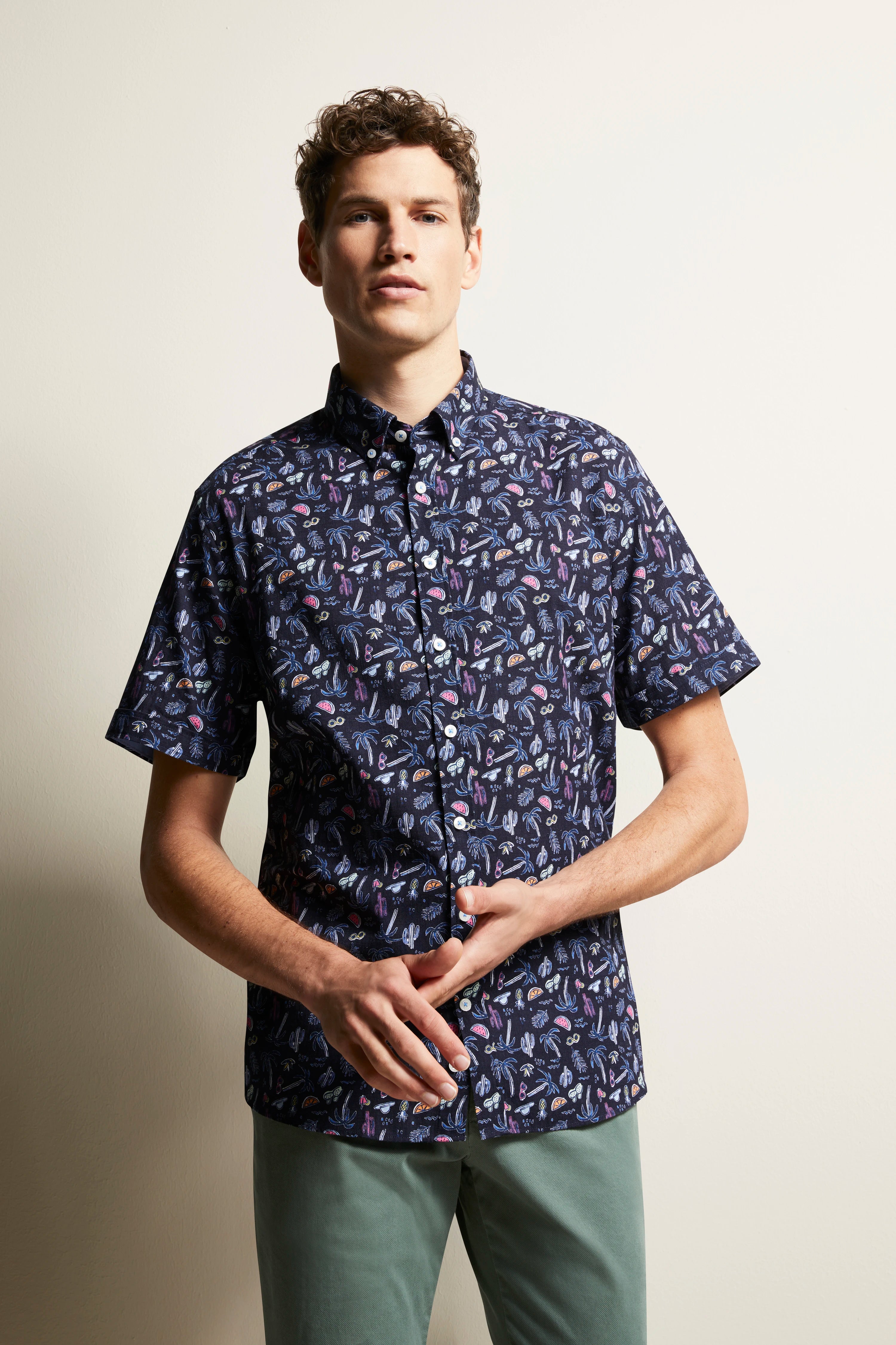 Short-sleeve shirt with colorful pattern, model in relaxed pose.