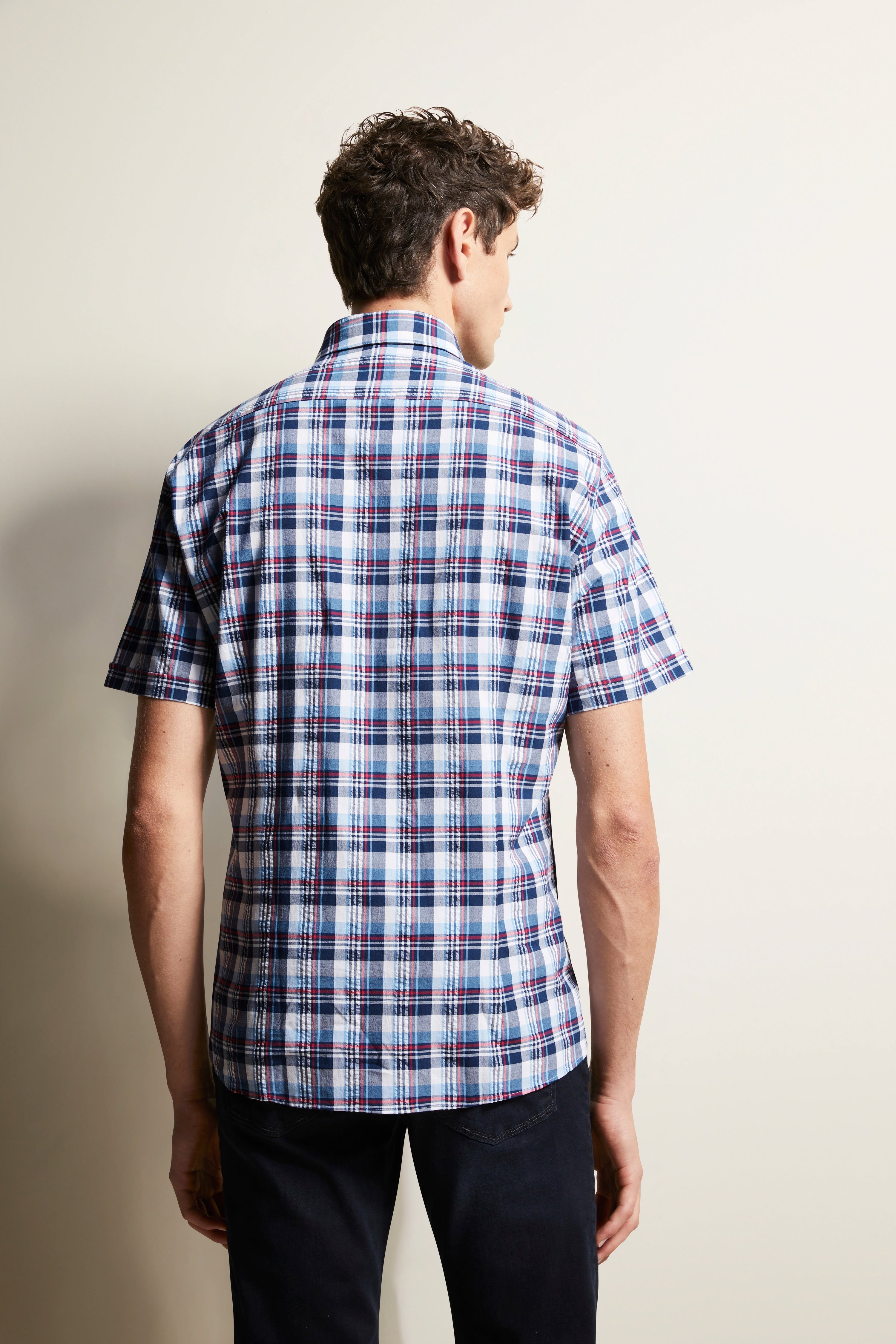 Kortemouw geruit overhemd in blauw-wit-rood, model van achteren, ontspannen outfit.