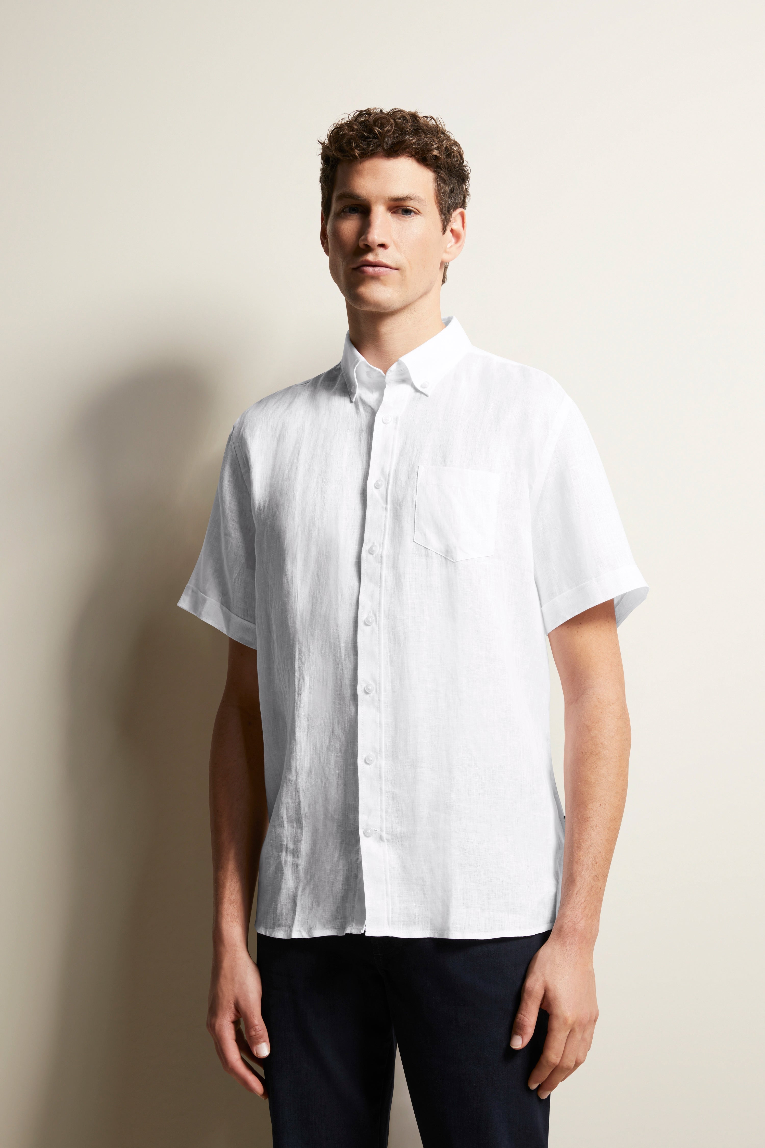 White short-sleeve shirt and dark pants by bugatti, embodying timeless elegance and Italian-inspired sophistication.