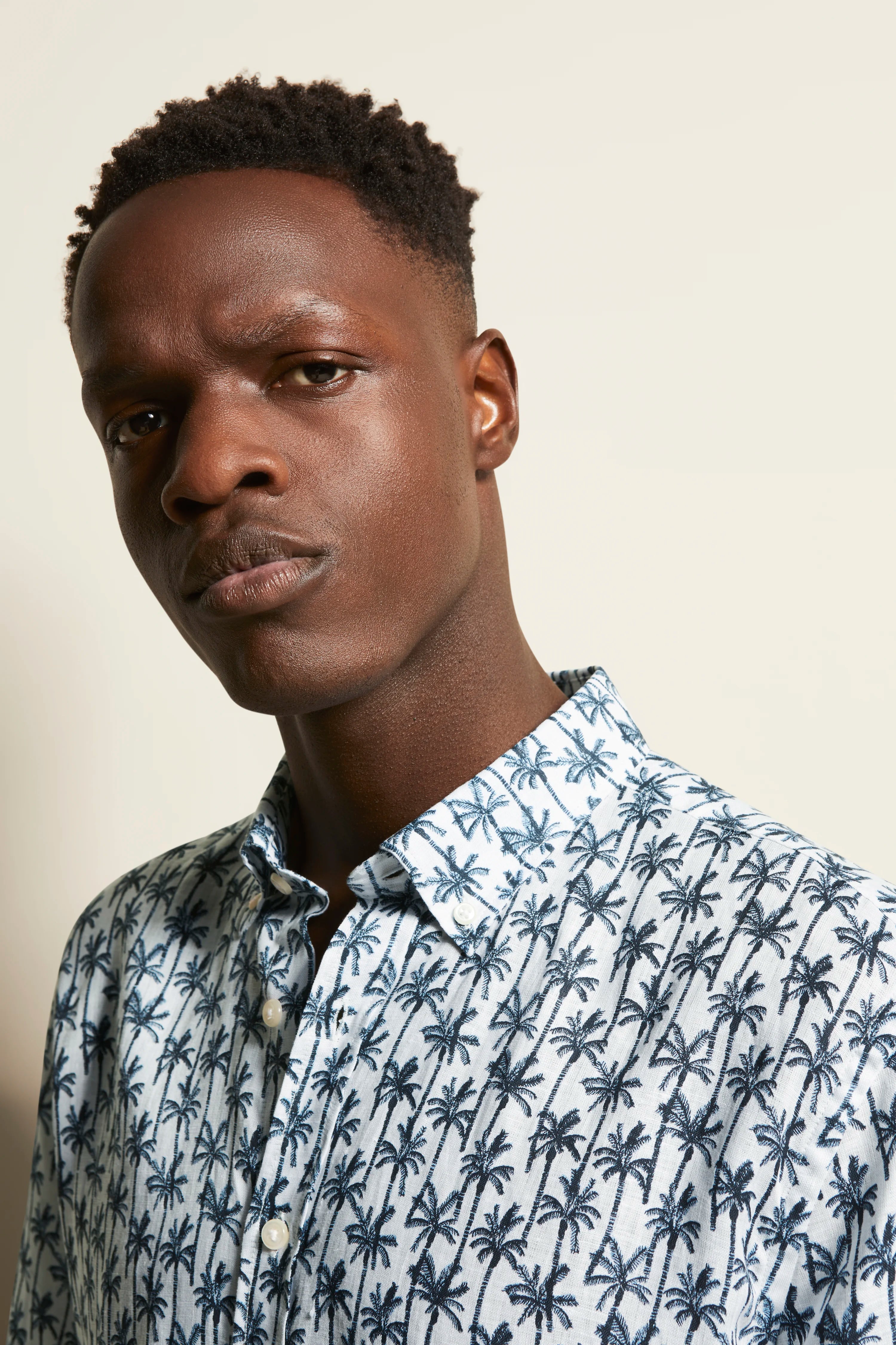 Bust shot with white shirt, blue palm pattern, relaxed pose, bugatti style.