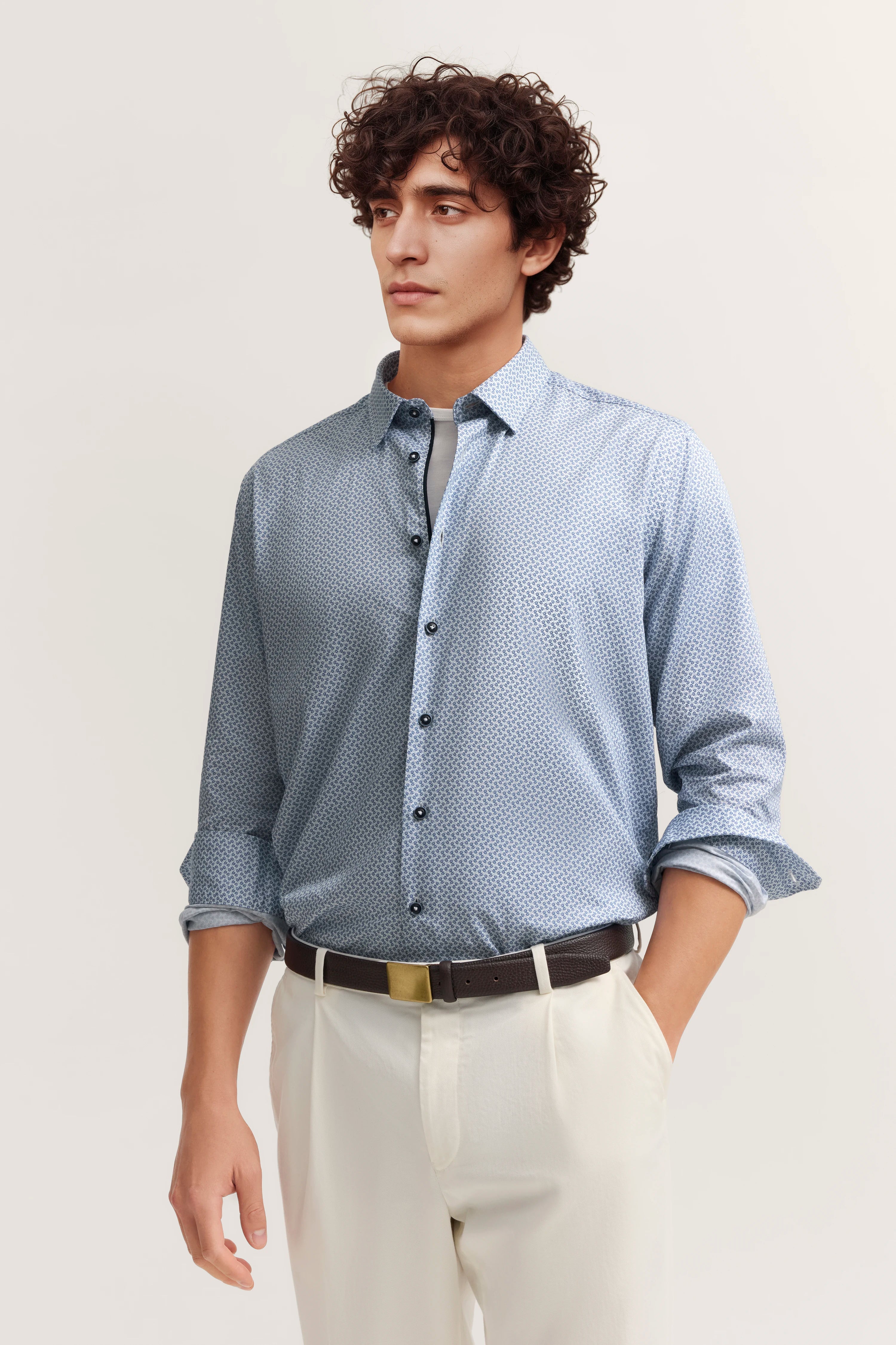 Bugatti Hemd mit blauem Muster, leger getragen, auf Model mit weißer Hose.