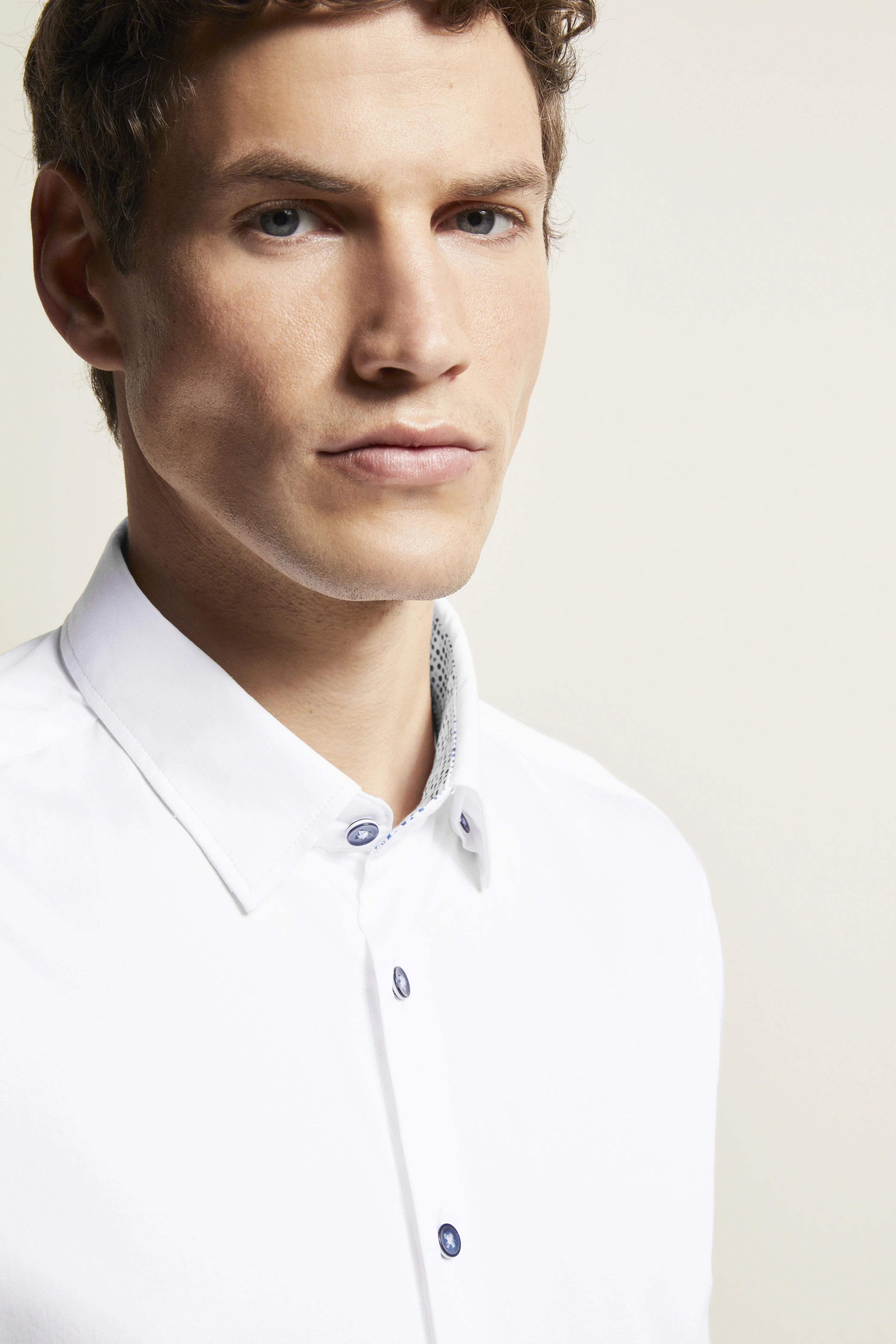 White bugatti shirt, model close-up, classic collar, blue buttons, timeless elegance.