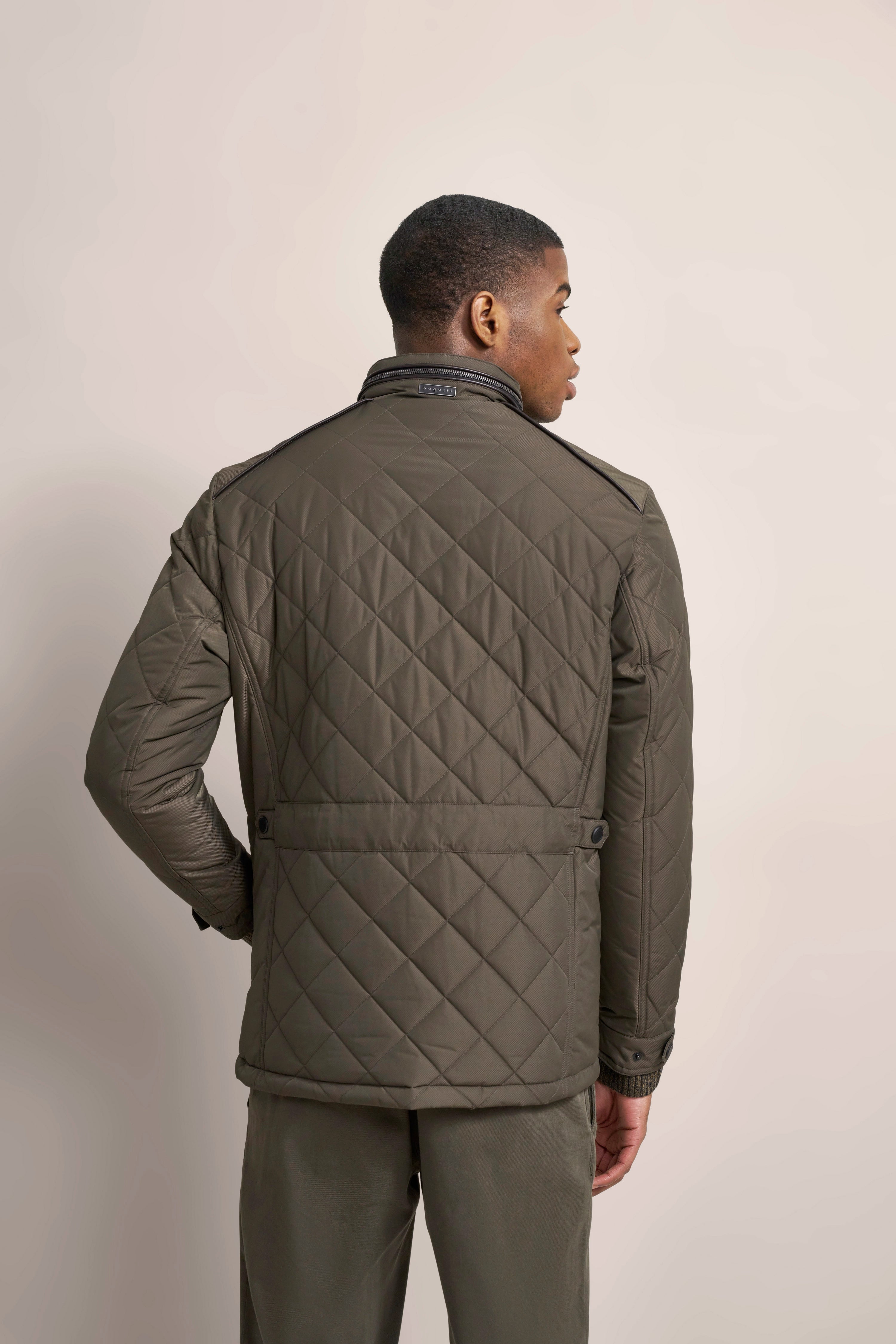 Quilted khaki jacket, back view, model posing with hand on hip, showcasing bugatti style.