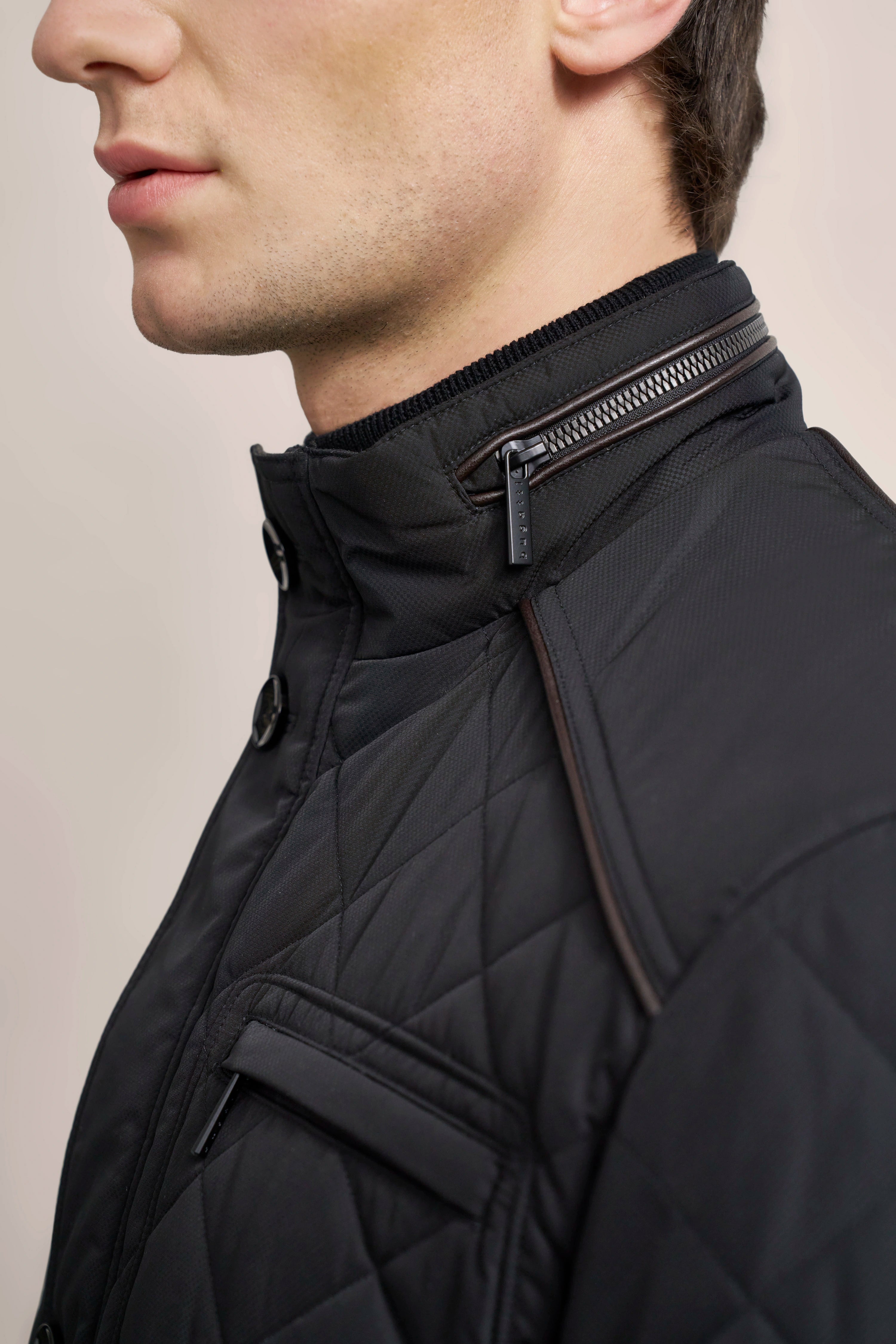 Schwarze bugatti Steppjacke mit Reißverschluss und Knopfleiste, Detailaufnahme.