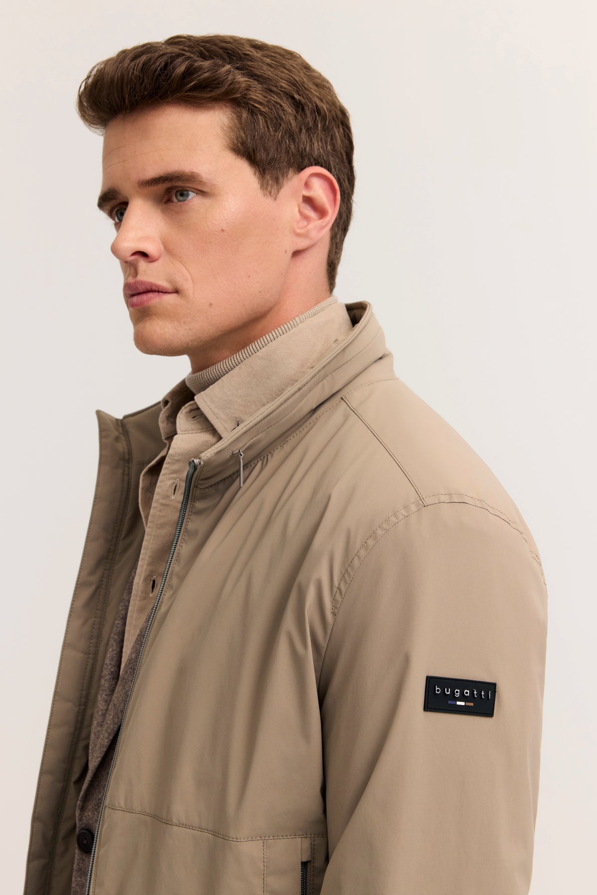 Beige bugatti Jacke und Hemd auf Model, Seitenansicht, entspannte Haltung.