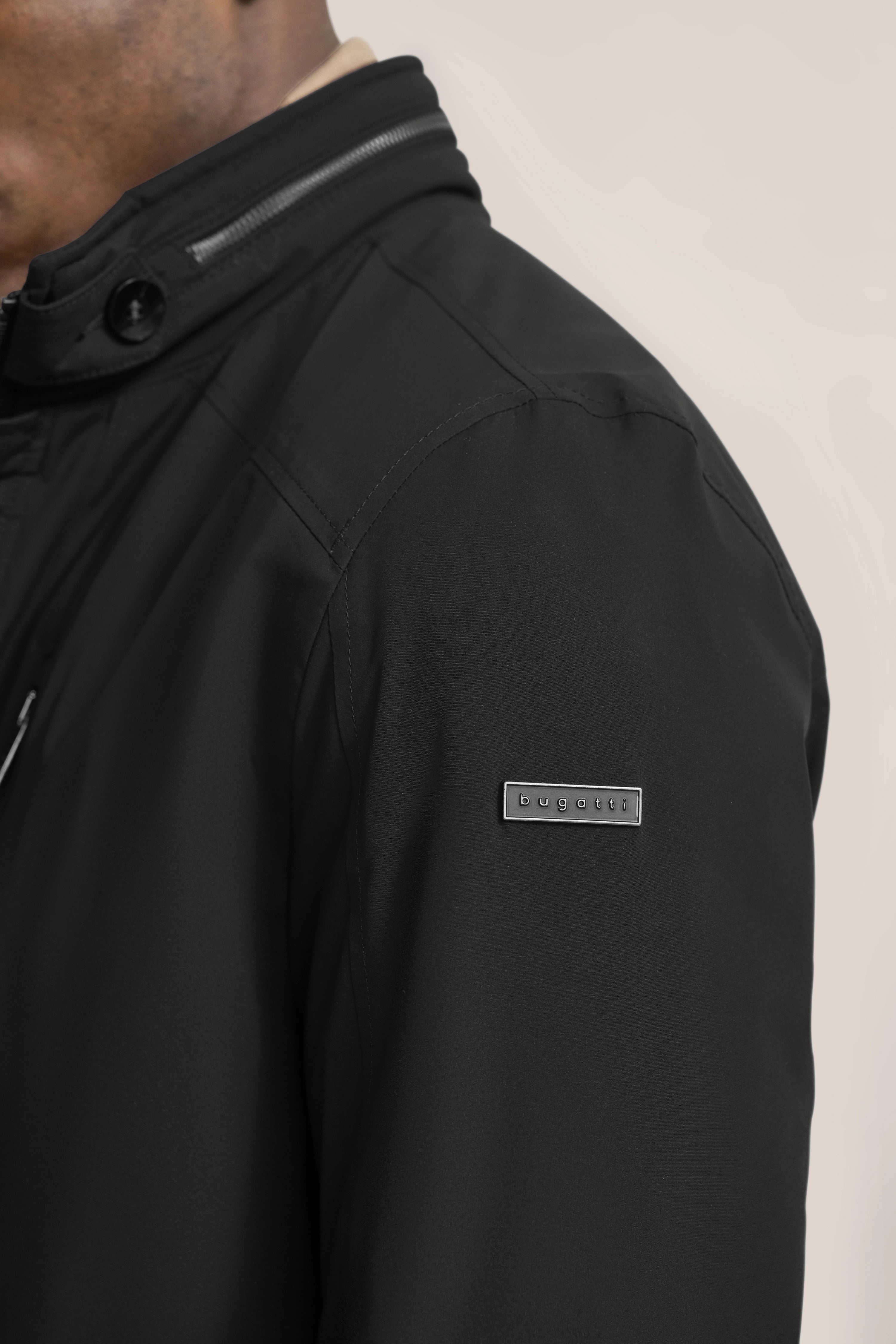 Schwarze bugatti-Jacke, detailreich, mit Reißverschluss und Knopf, elegantes Design, Büstenbild.