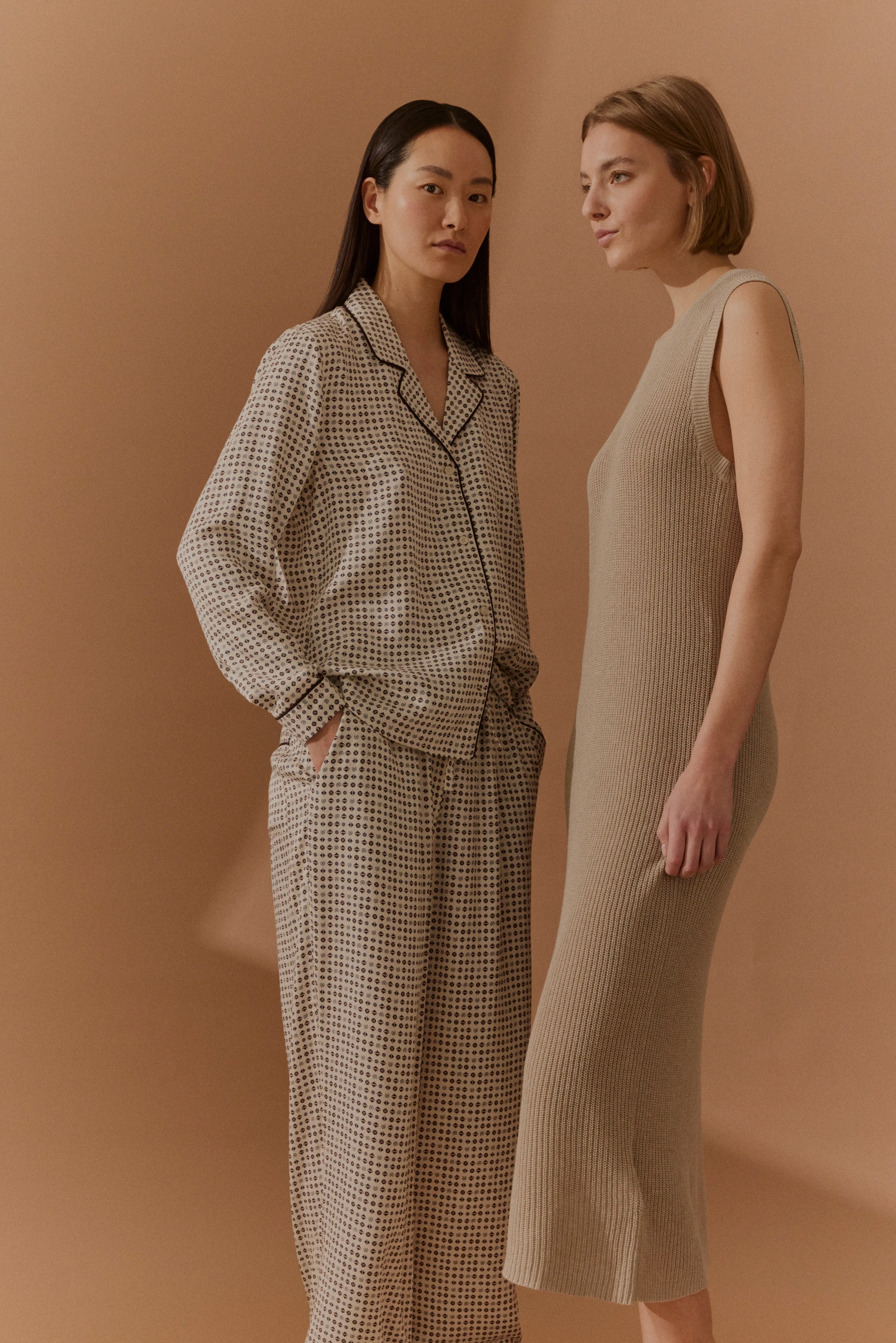 Zwei Models in gemustertem Pyjama und beige Strickkleid, entspanntes Posing, bugatti Stil.