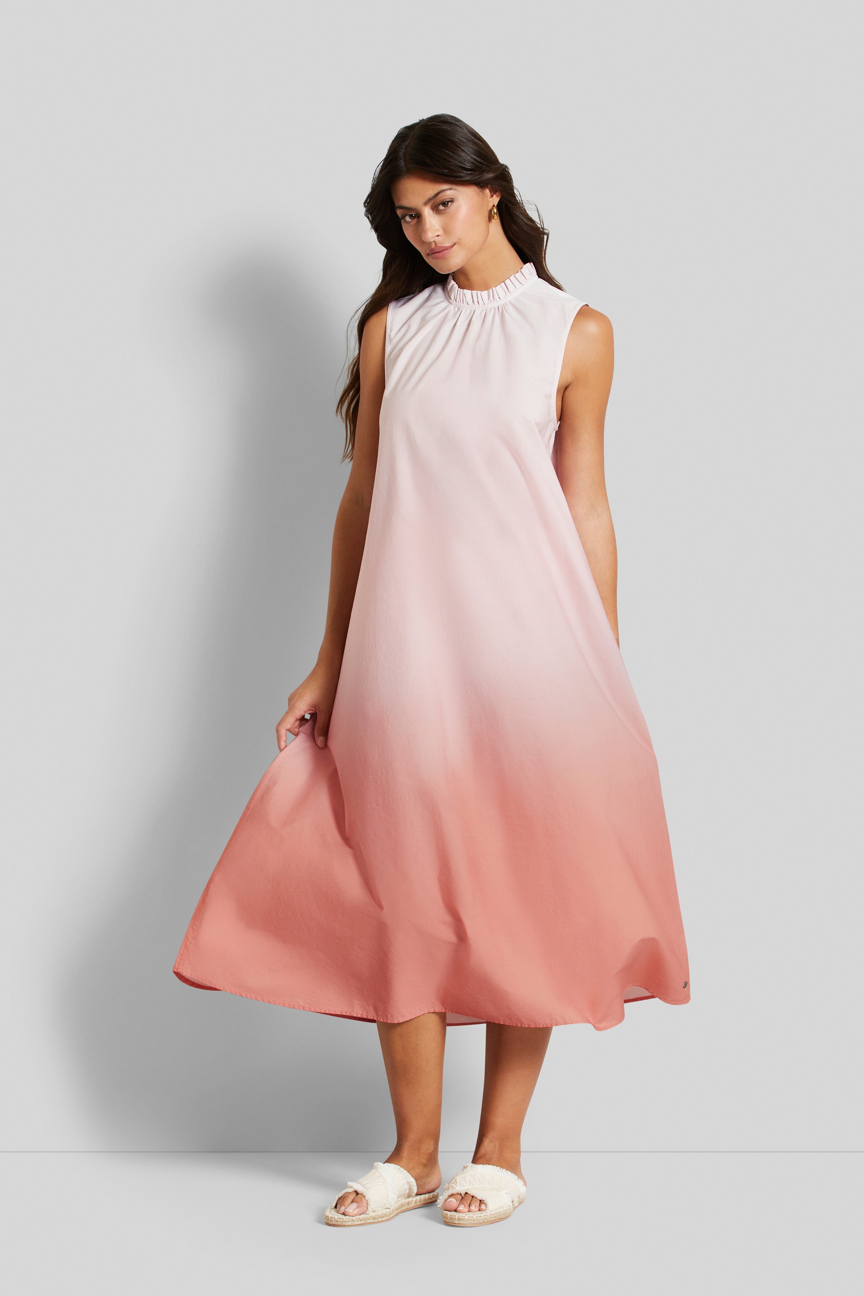 Model im ärmellosen Ombre-Kleid in Rosa-Pfirsich, entspanntes Posing, bugatti Stil.