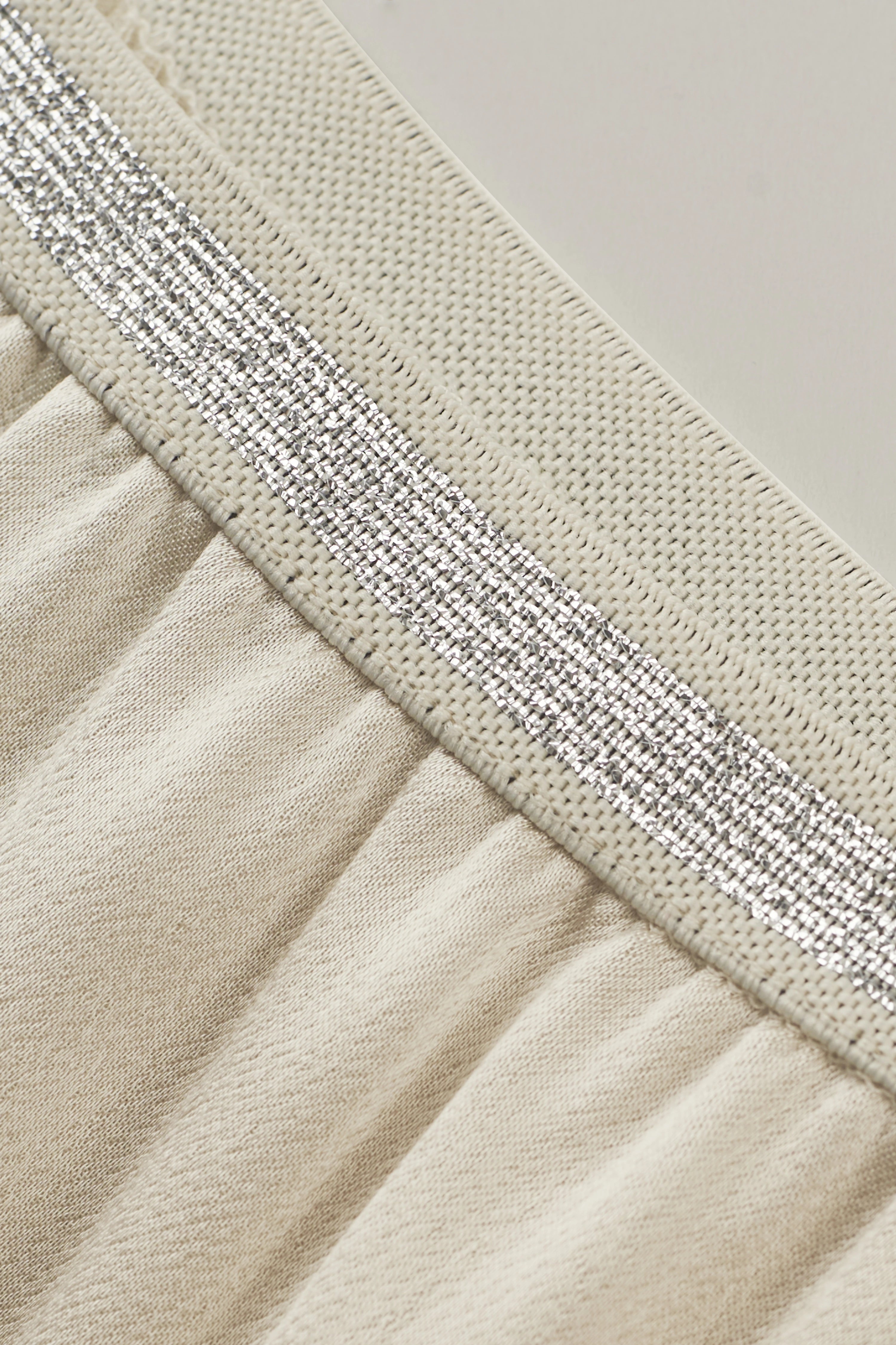 Beige stof met zilveren streep, close-up. Buste. Elegantie van bugatti.