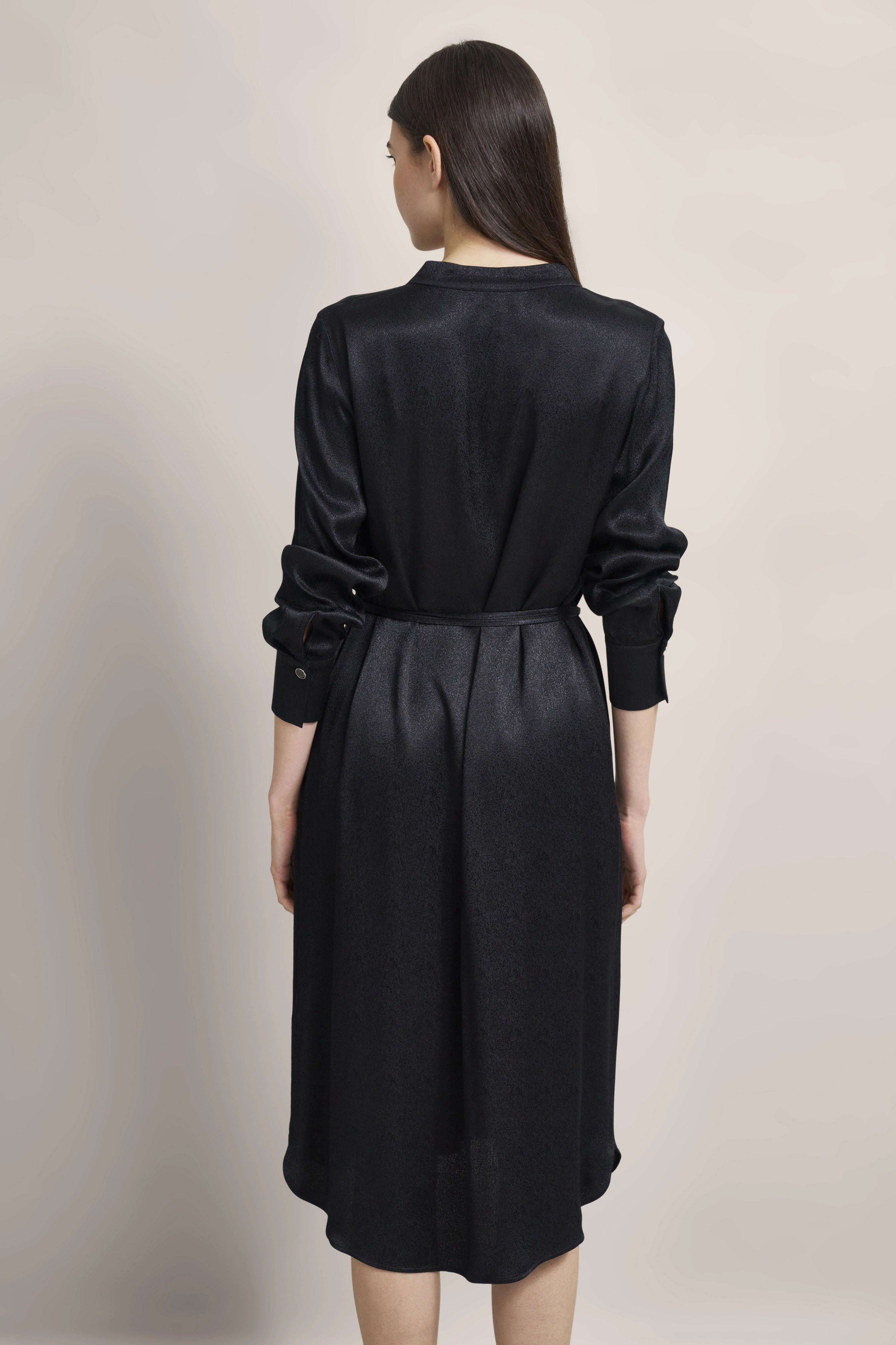 Black bugatti dress, model in long sleeves and belt, rear view.