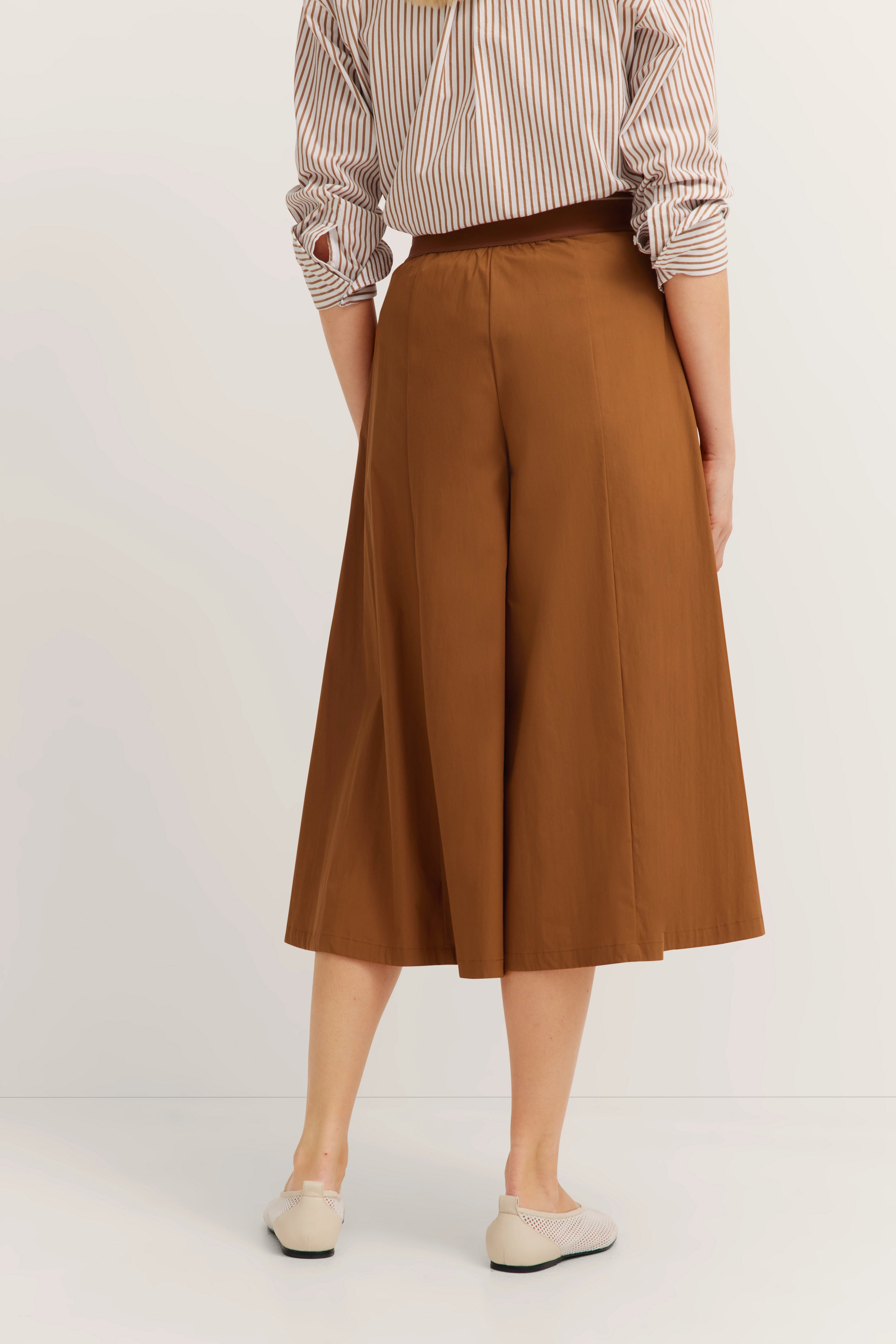 Braunes Culotte-Outfit mit gestreiftem Hemd, legeres Modelbild von hinten.