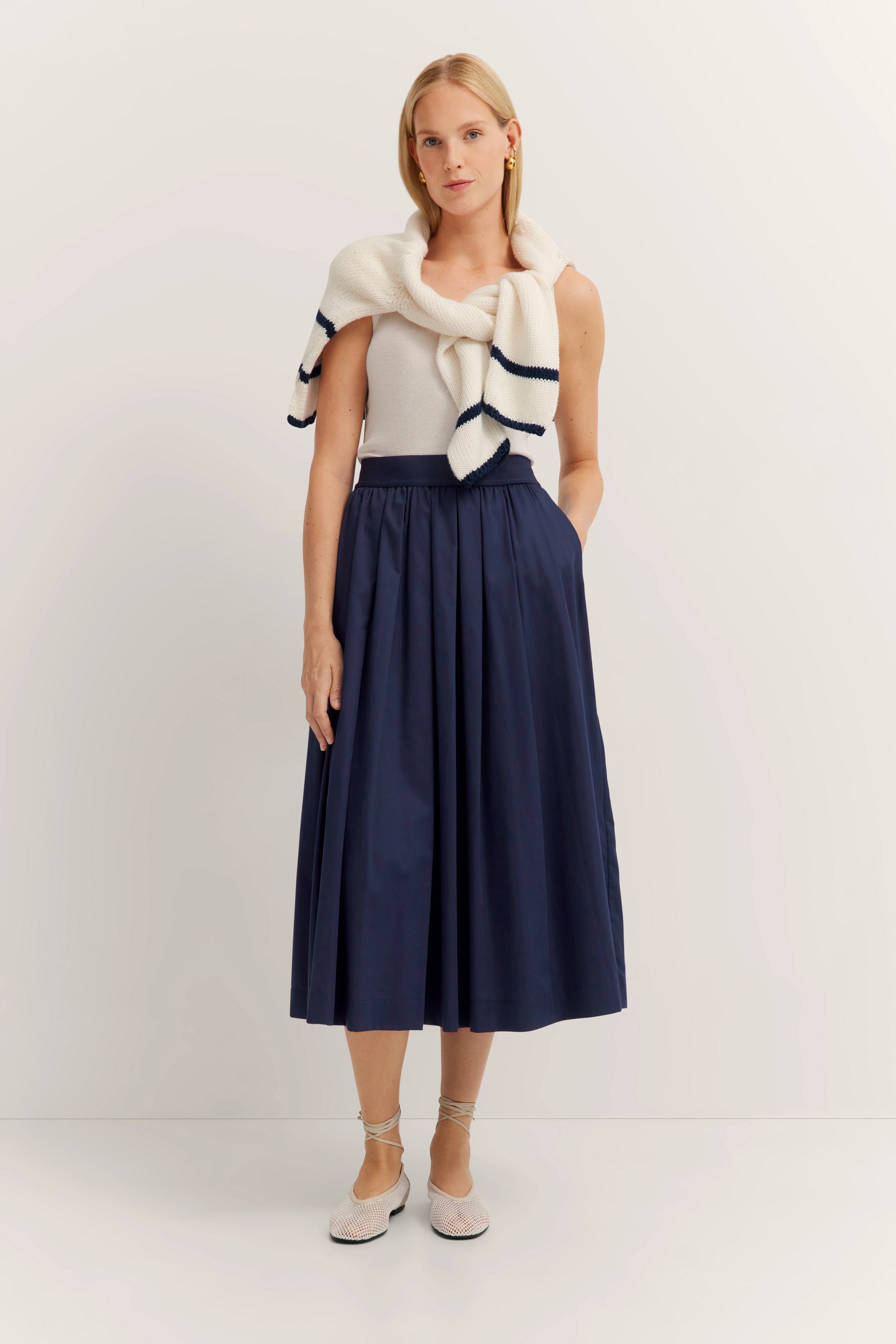 Model in wit top, blauwe rok