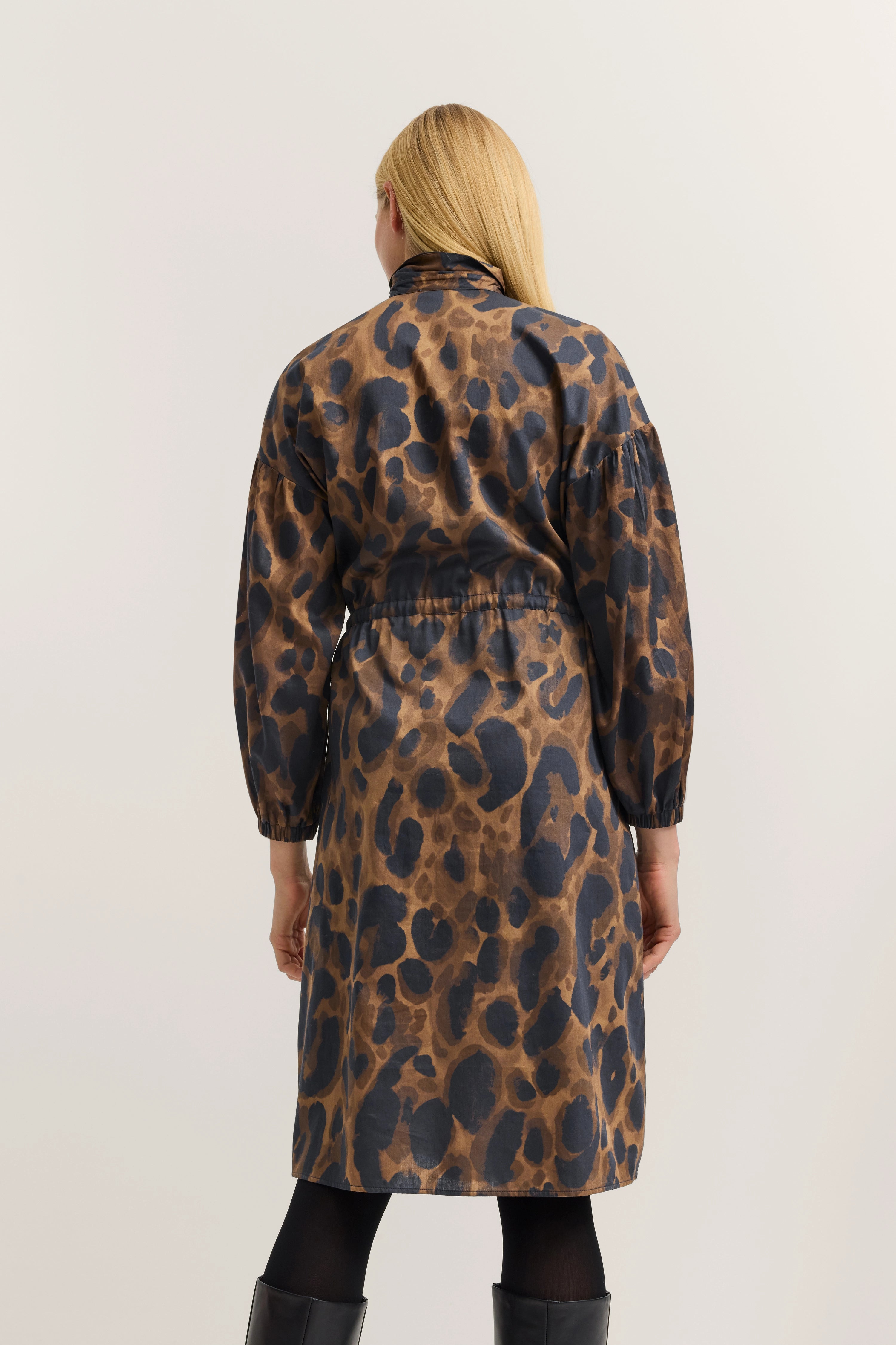 Back view of model in long, dotted brown and black dress by bugatti.