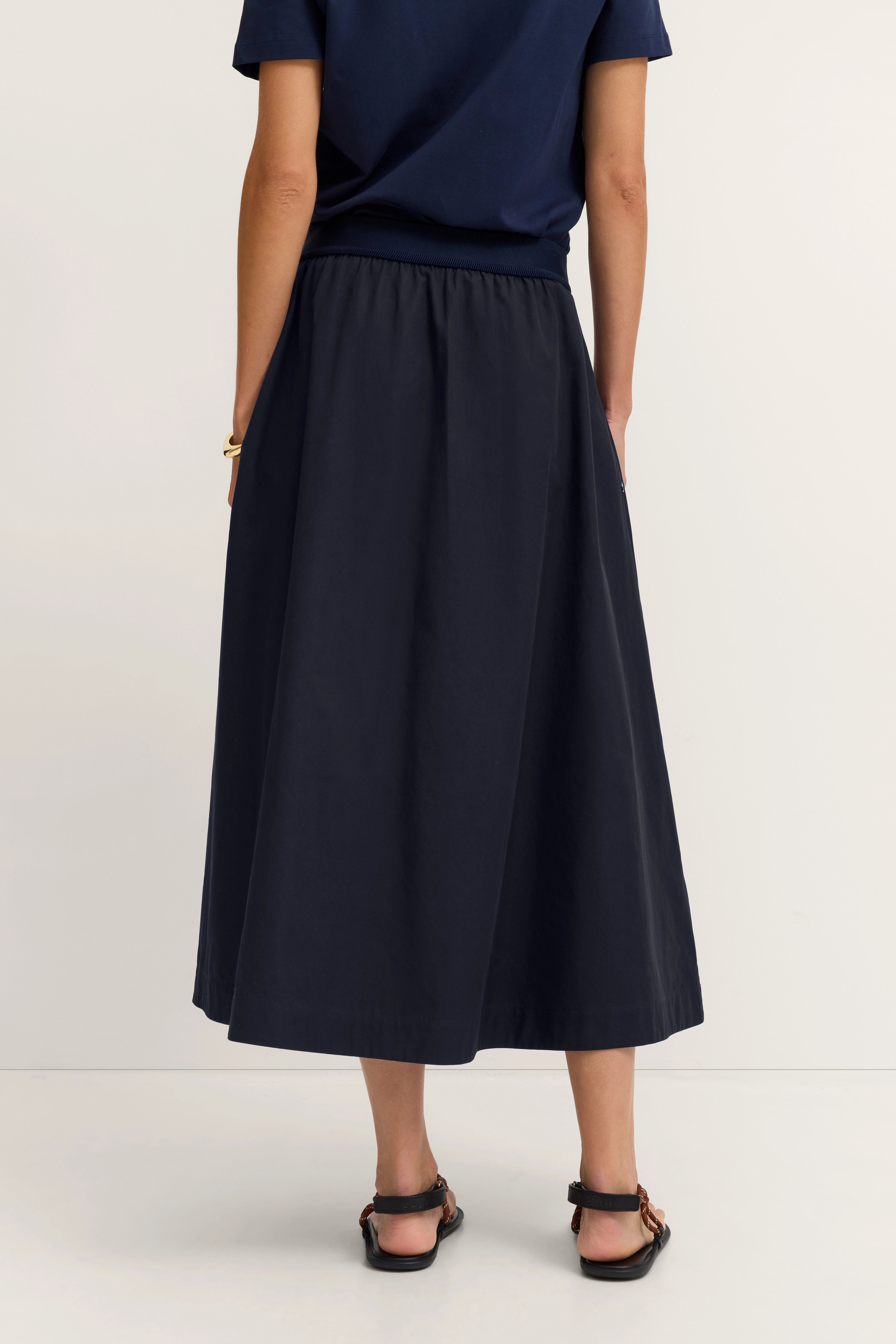 Navy blaues Outfit von bugatti, T-Shirt und Midi-Rock, legeres Modelbild, Rückenansicht.
