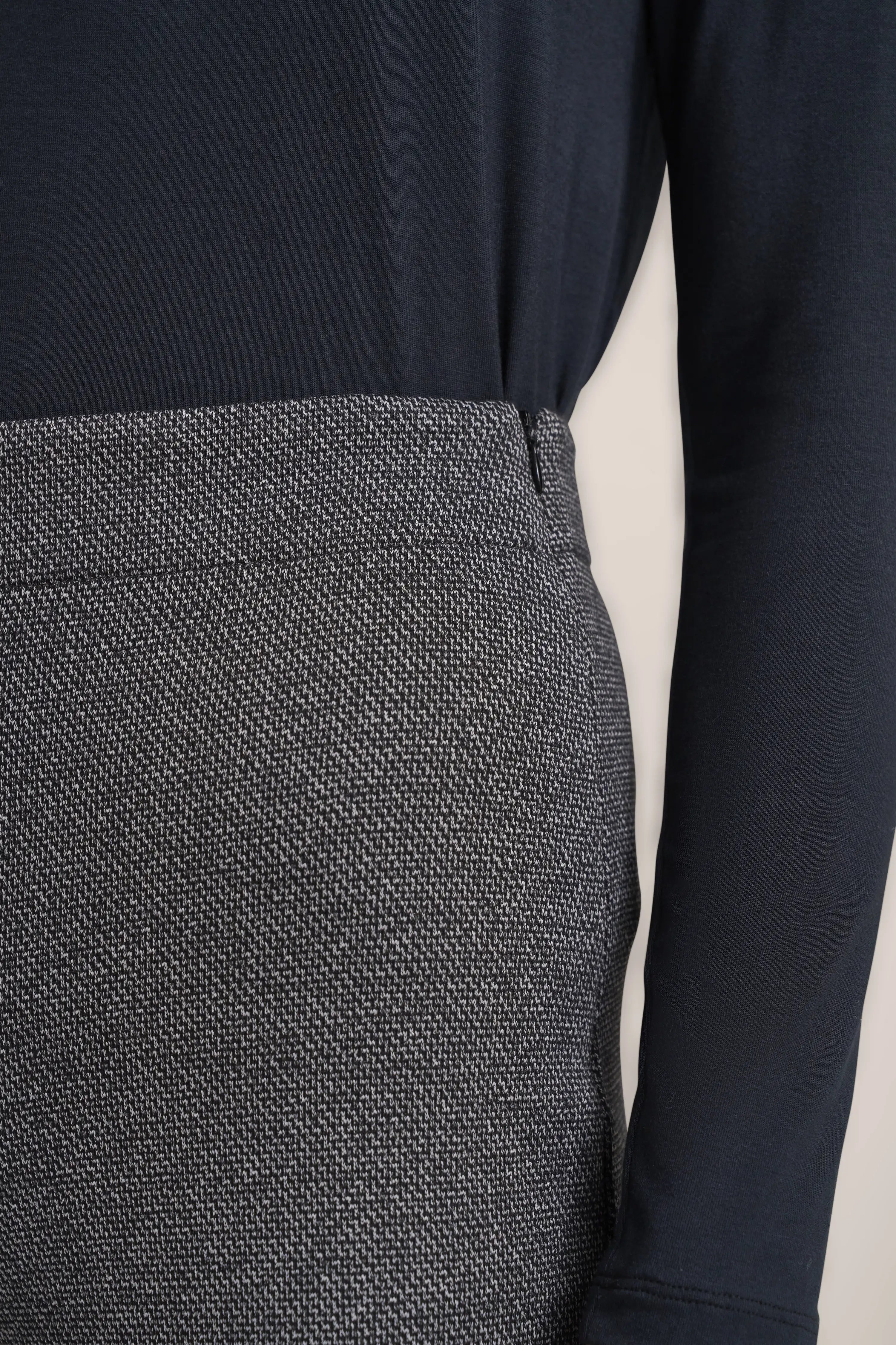 Schwarzer Langarmtop mit grauem, gemustertem Rock, Büstenbild von bugatti.