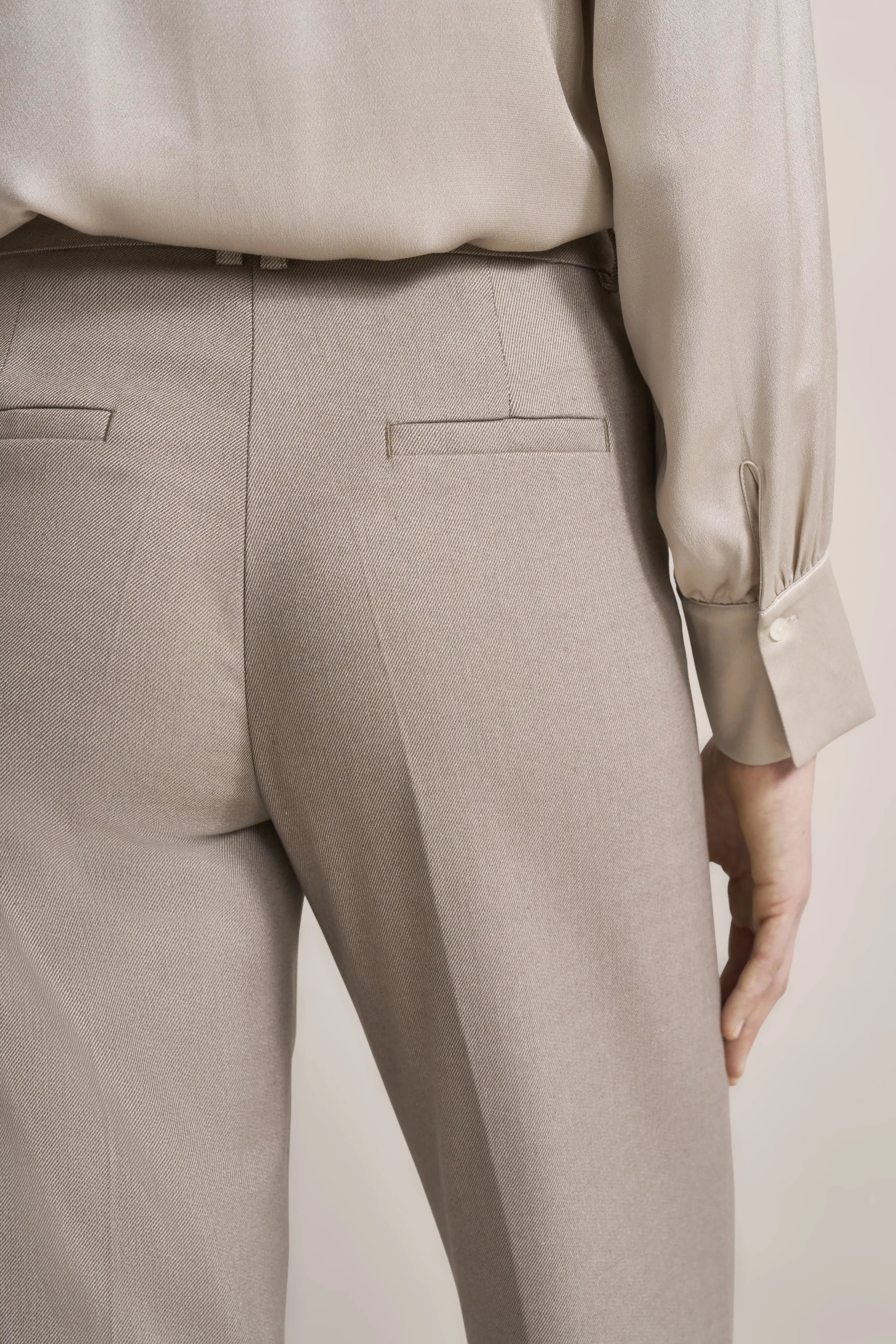 Beige pants and blouse in casual bust shot by bugatti, simple elegance in neutral tones.