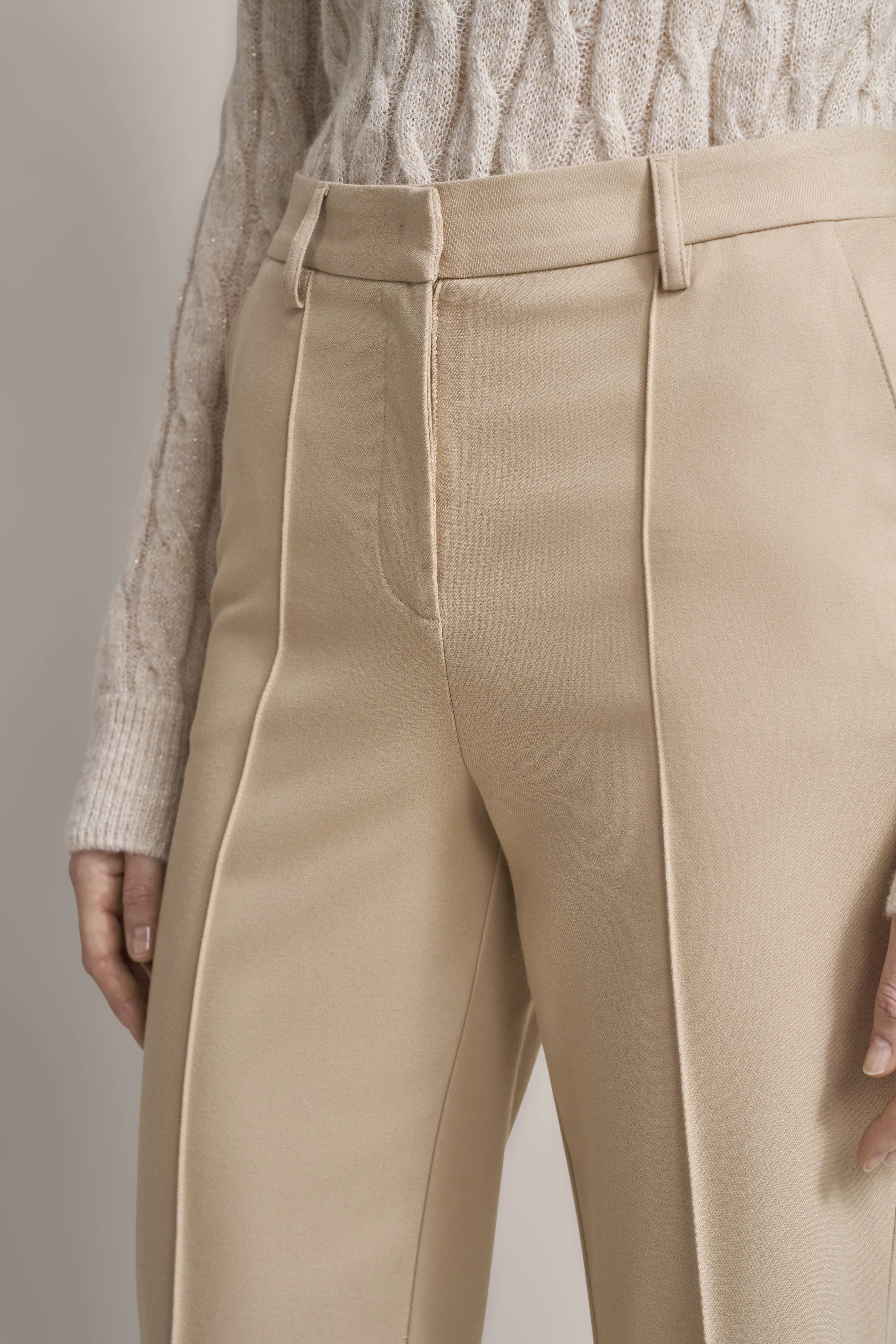 Beige bugatti trousers paired with cable knit sweater, bust view.