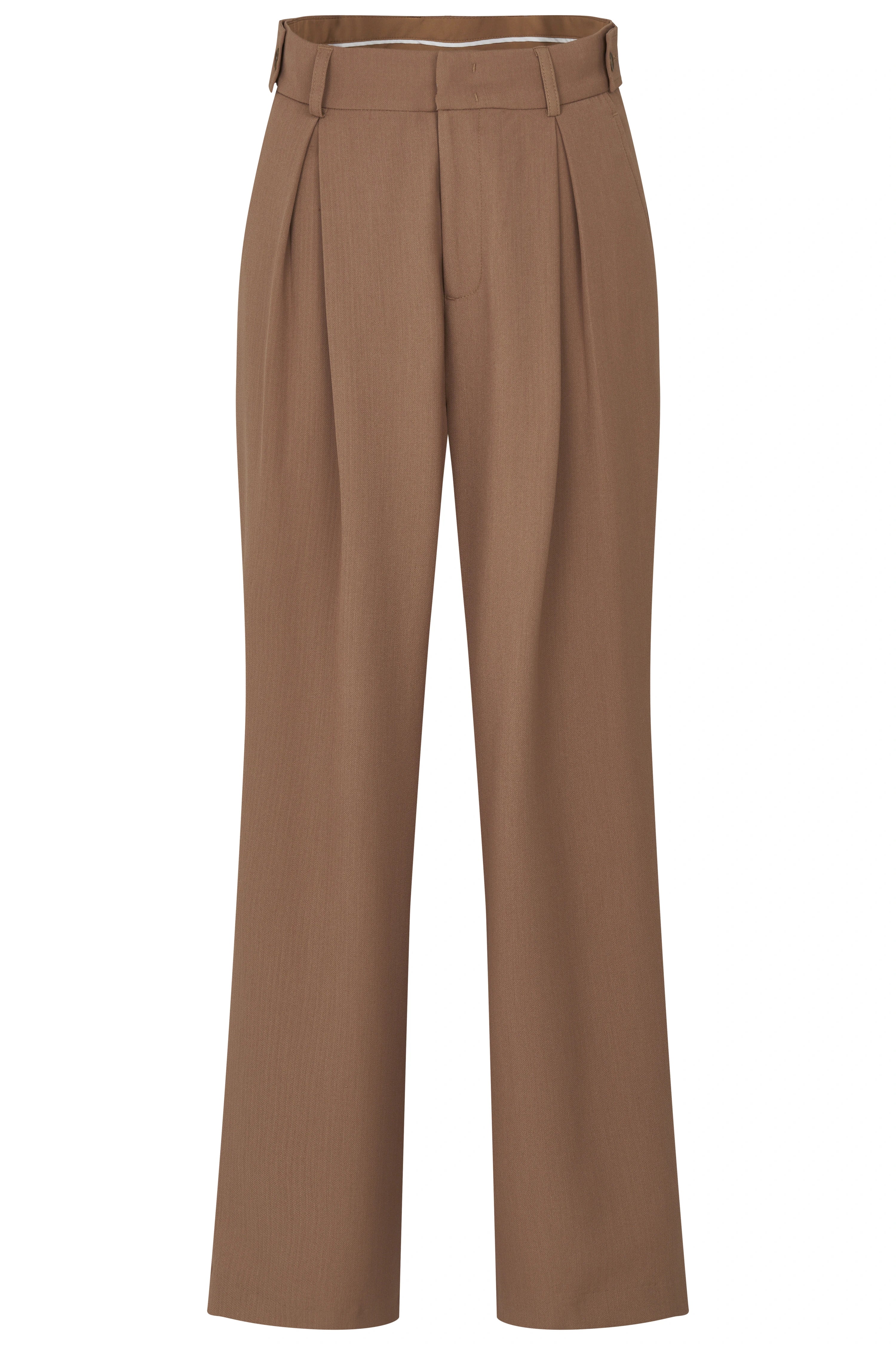 Model in white tank top, brown pants, beige shoes, posing sideways.